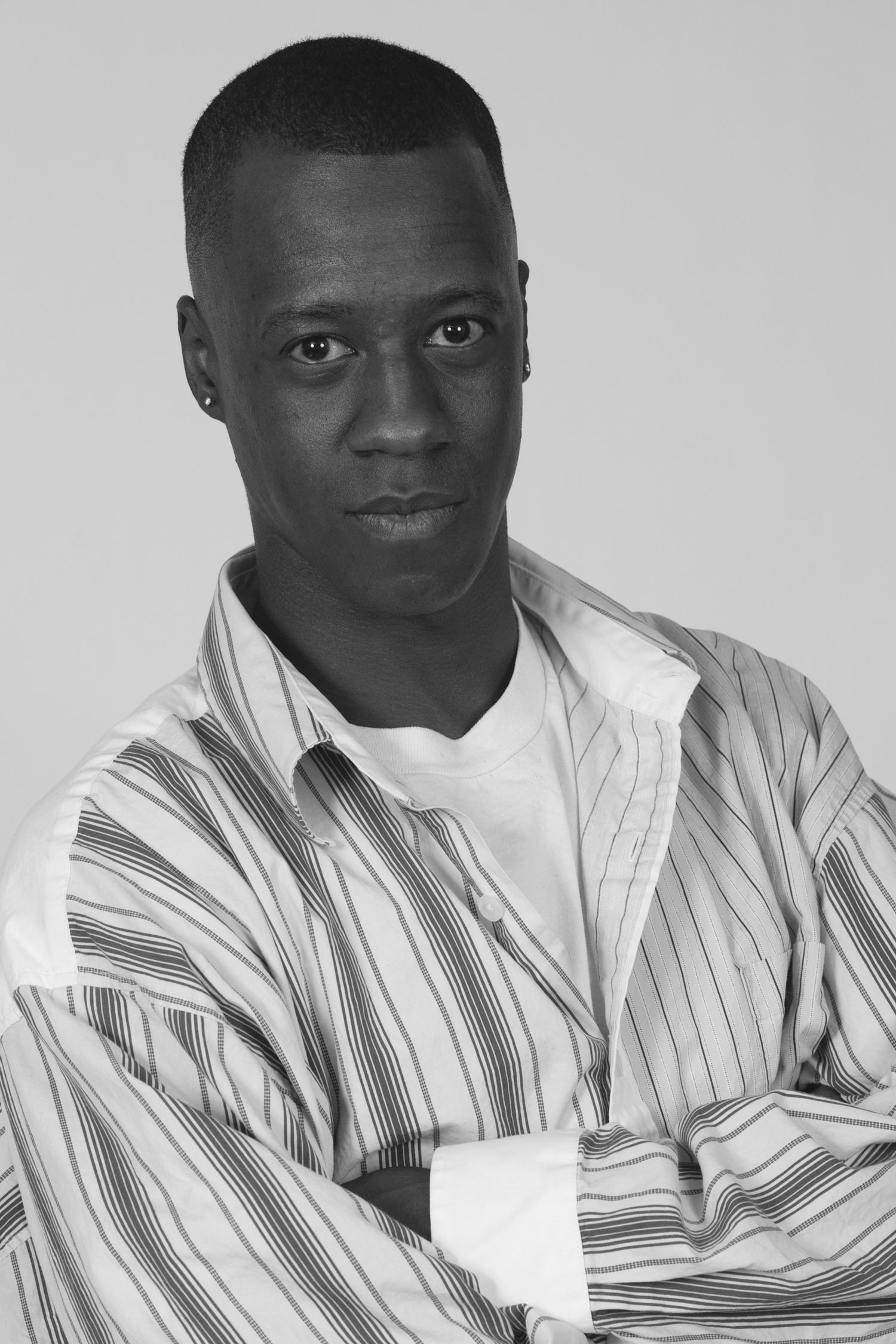 Professional headshot wearing striped button-down shirt against neutral background.