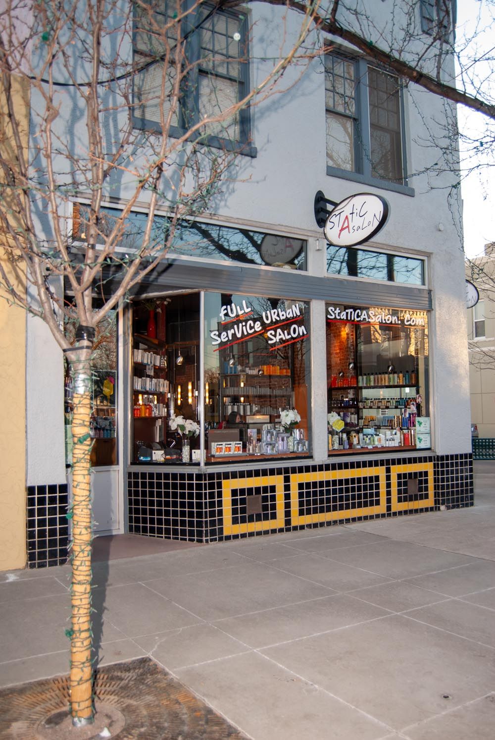 Modern retail storefront with large windows displaying salon services and merchandise.