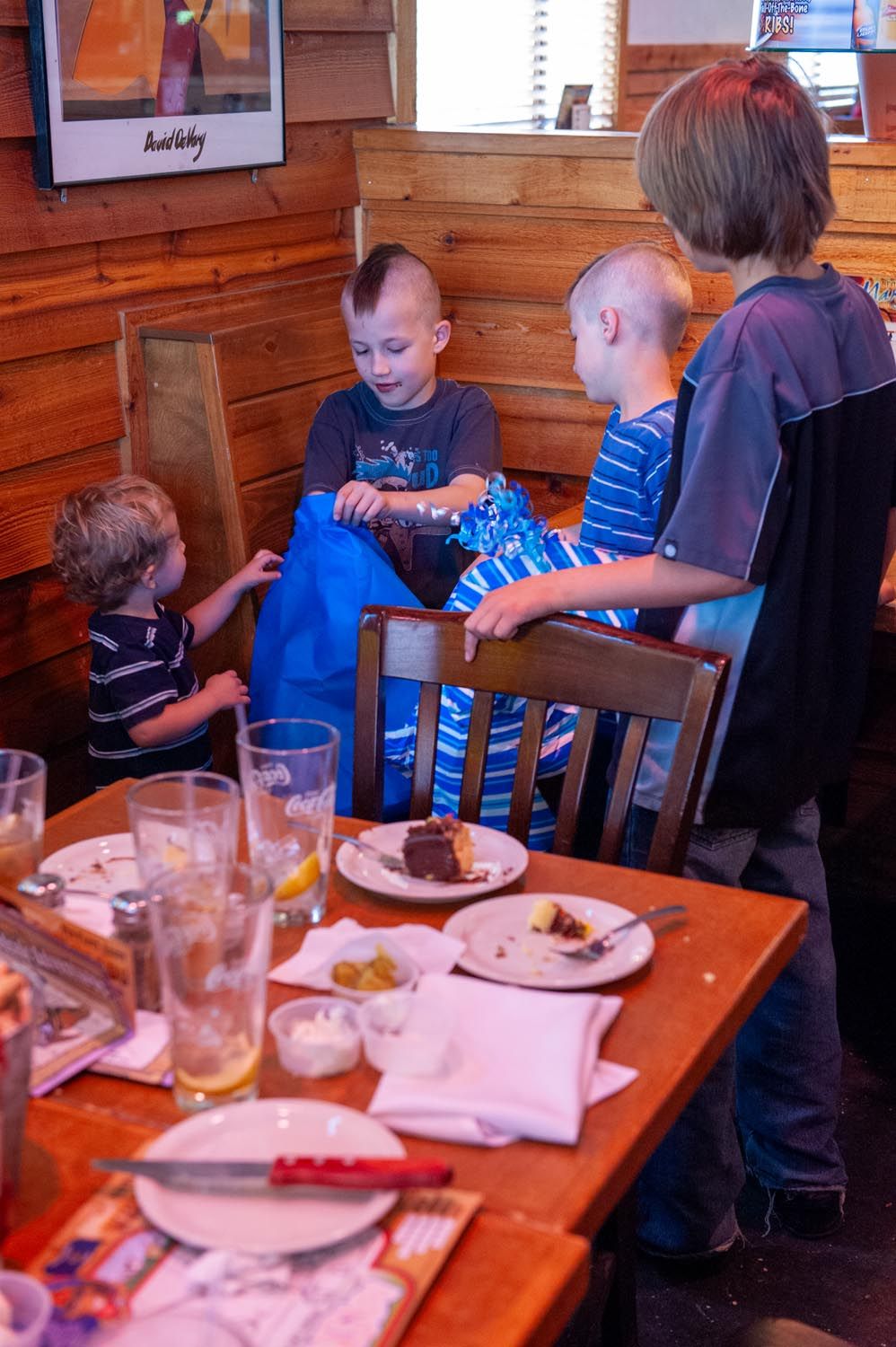 Group enjoying a casual meal together at a rustic restaurant with wooden walls and tables.