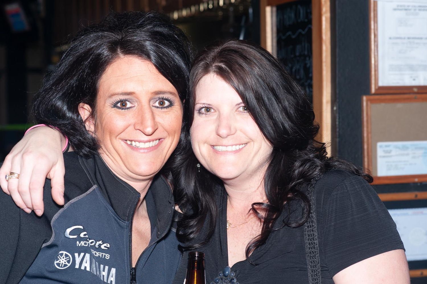 A series of four similar photos showing two people posing together at what appears to be a restaurant or bar.