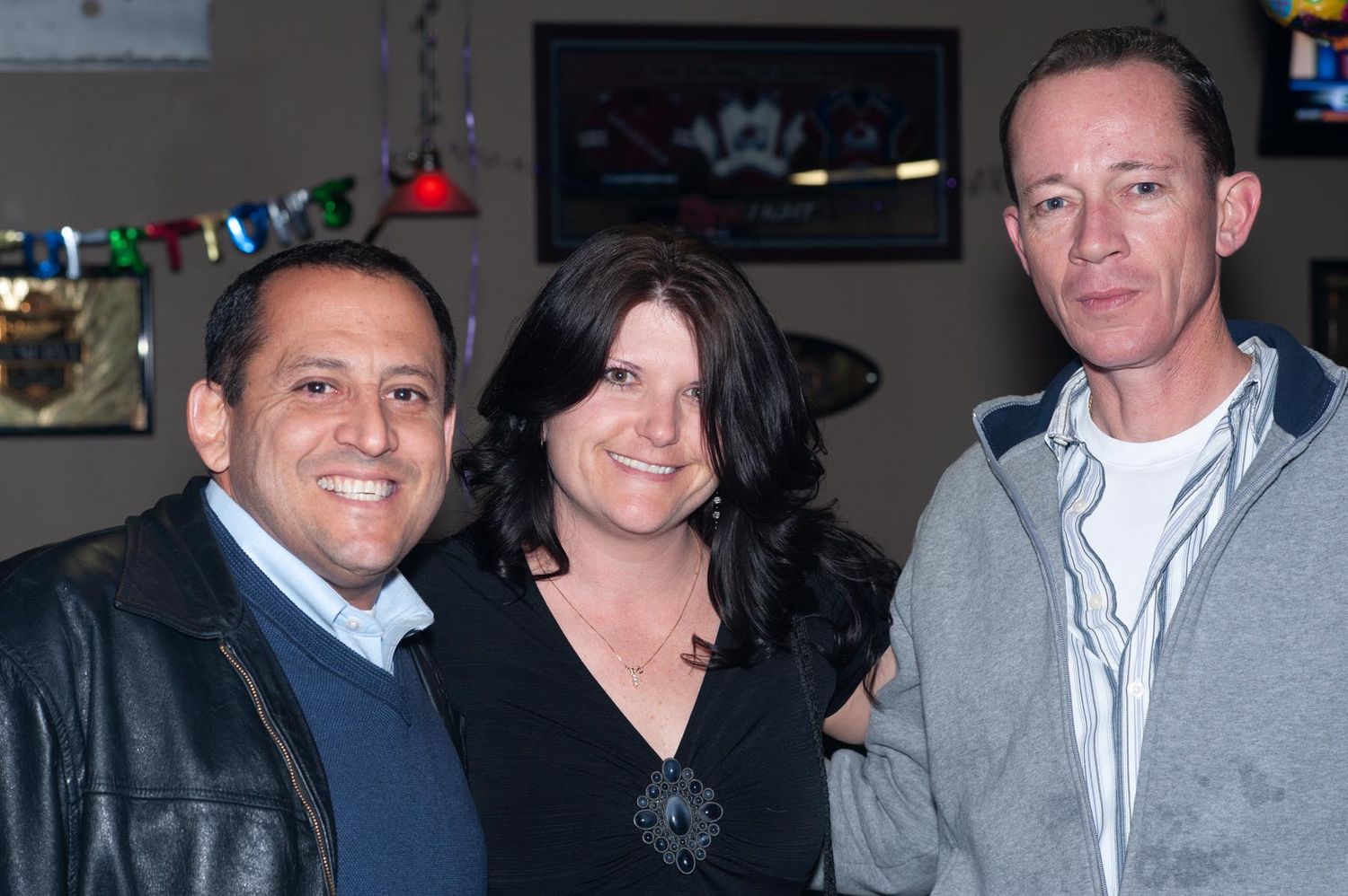 A group of people wearing casual business attire gather together at what appears to be a social or networking event.