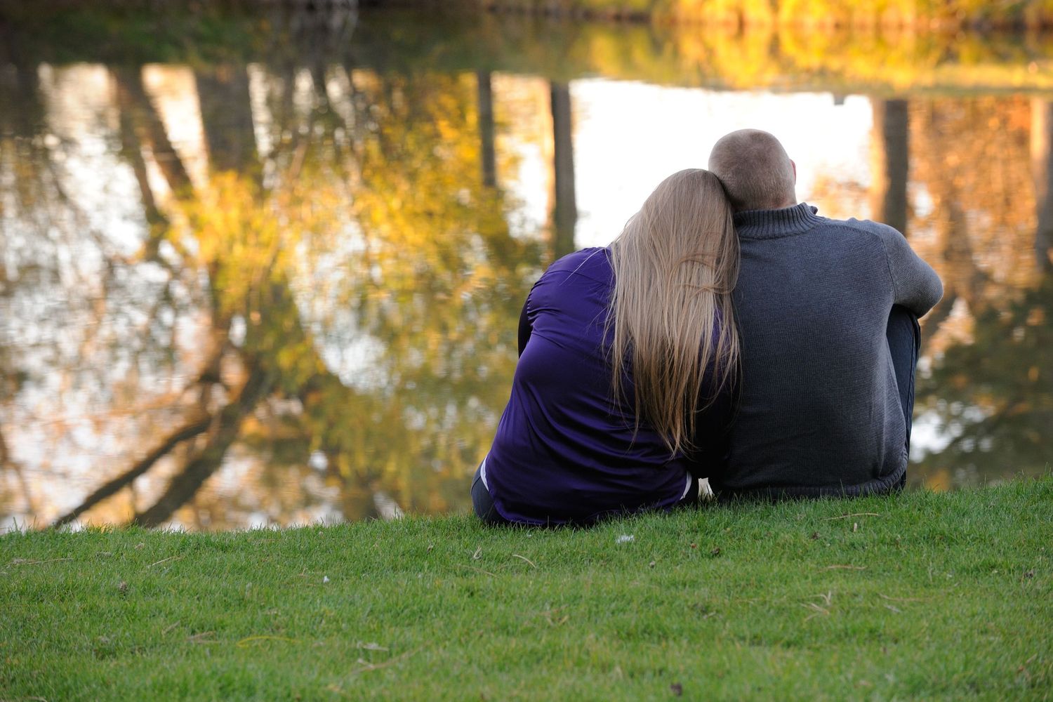 A sequence of autumn photos showing someone lying in fallen leaves on grass during golden hour.