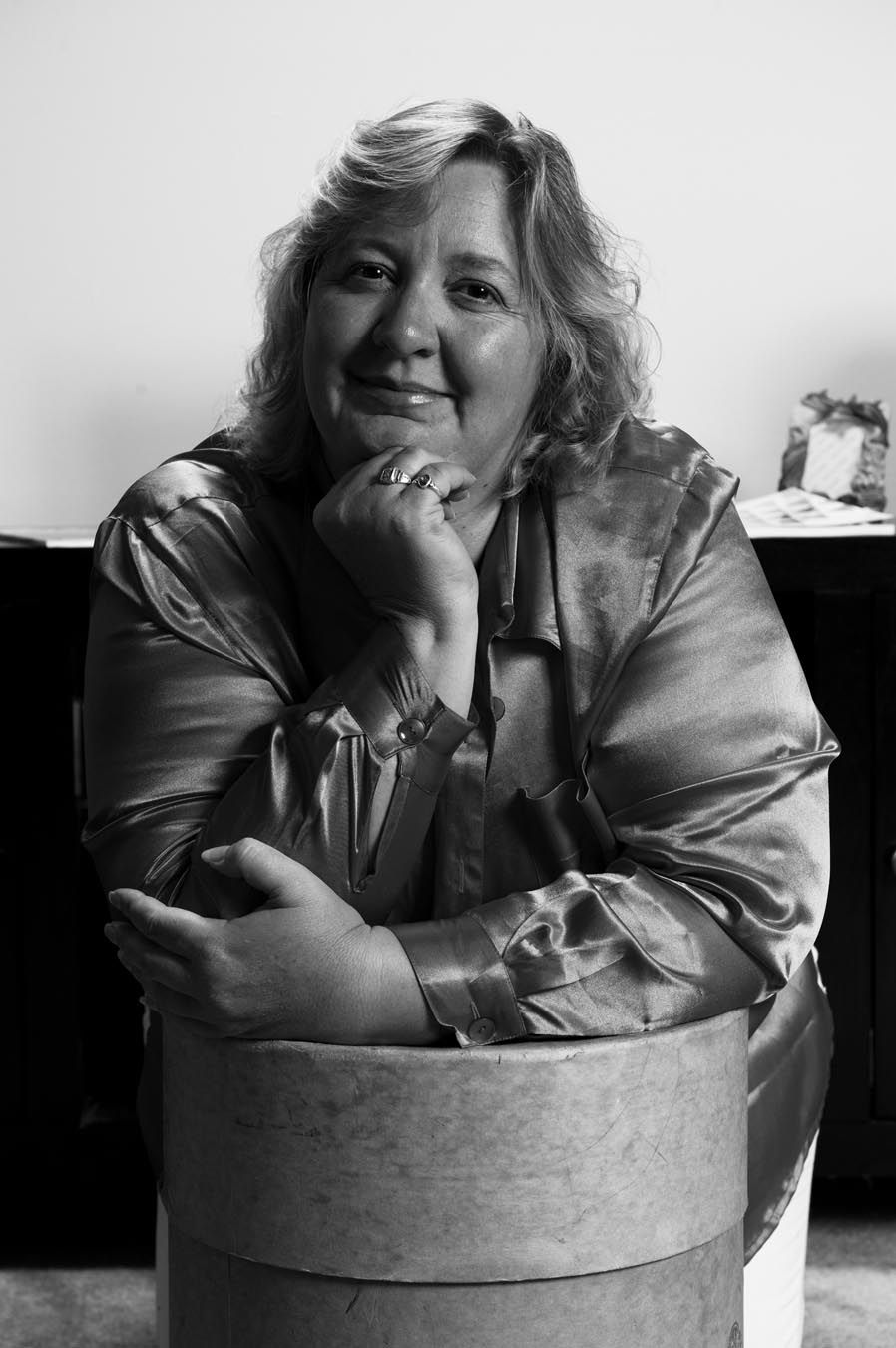 Black and white portrait series showing someone posing playfully in a round container.