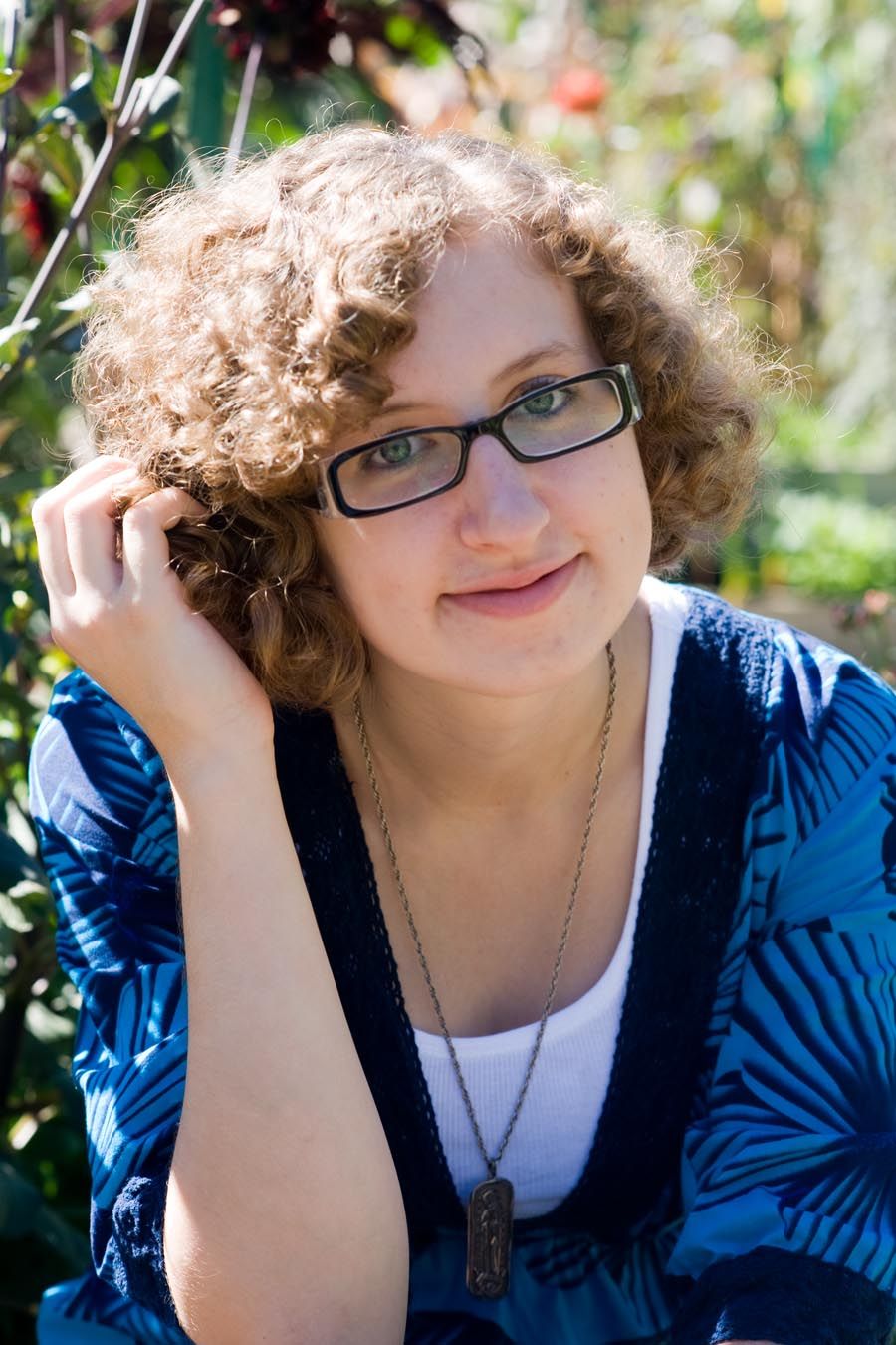Casual outdoor portrait series featuring curly hair and glasses.