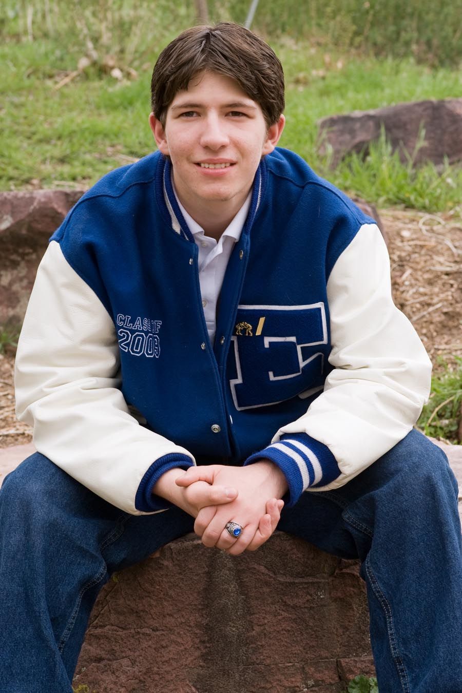 Casual outdoor portrait series in blue and white varsity jacket.