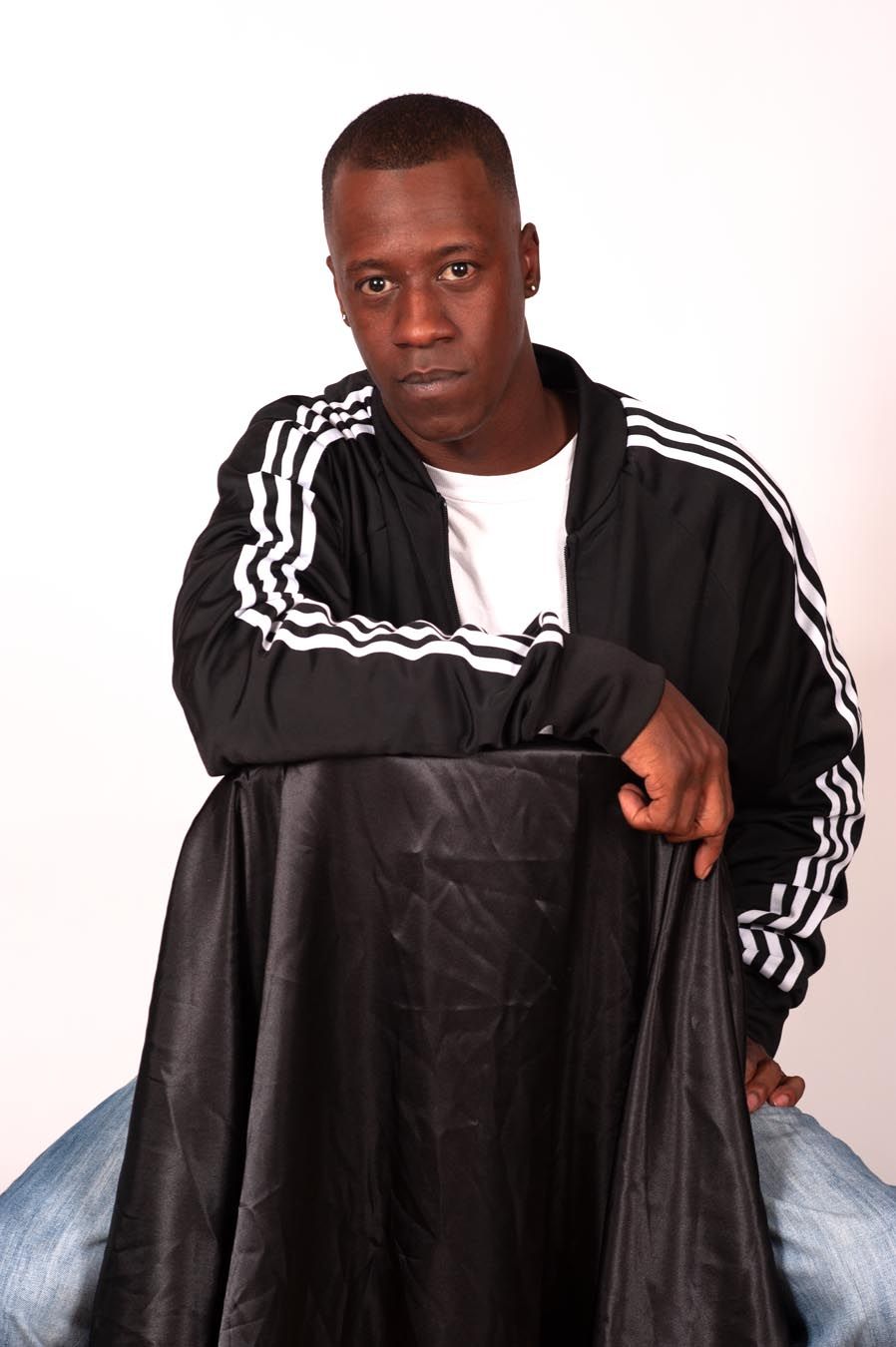 Athletic pose series in black Adidas jacket against white background.