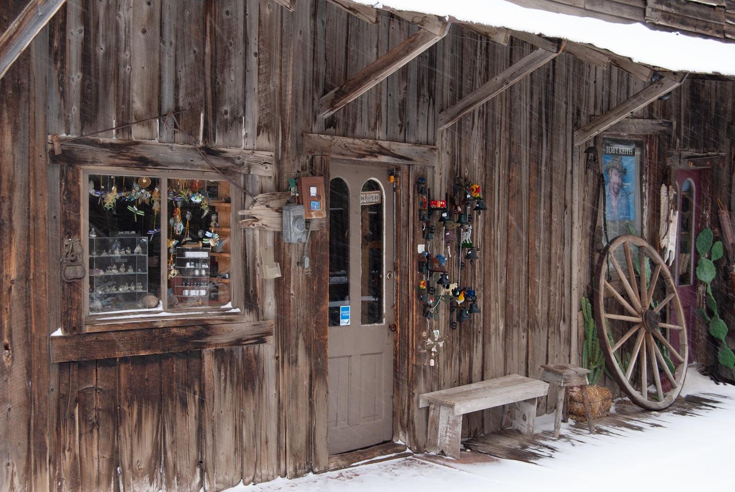 Rustic wooden storefronts and wagon wheels create an old west atmosphere in winter.