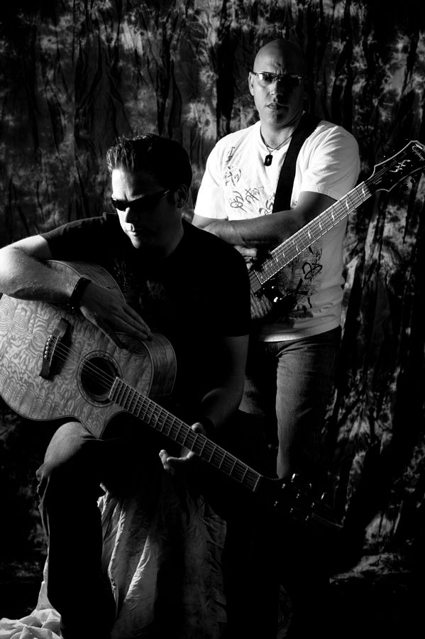 Black and white photos of acoustic guitar players performing in dramatic lighting.