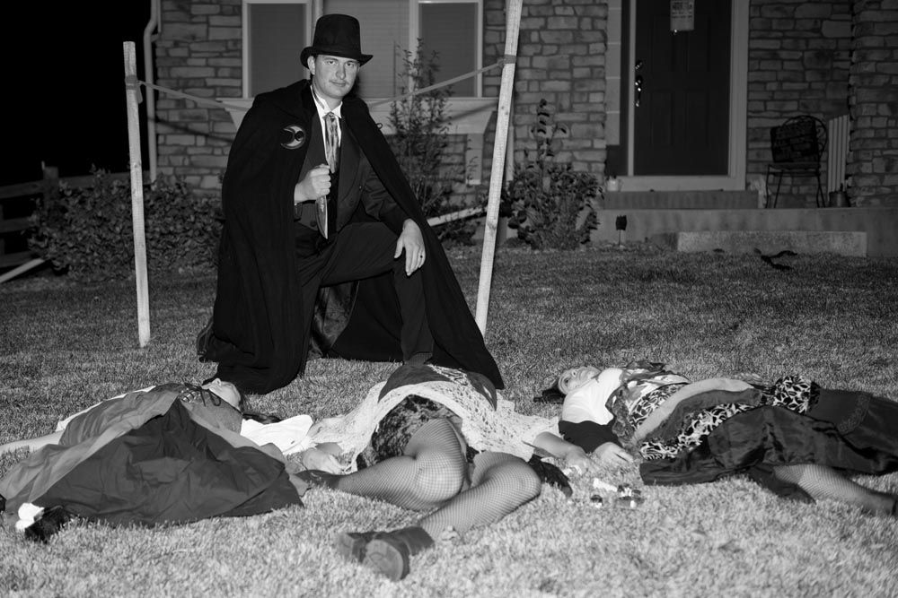 A sequence of black and white photos showing someone in a top hat lying down on grass in different positions.