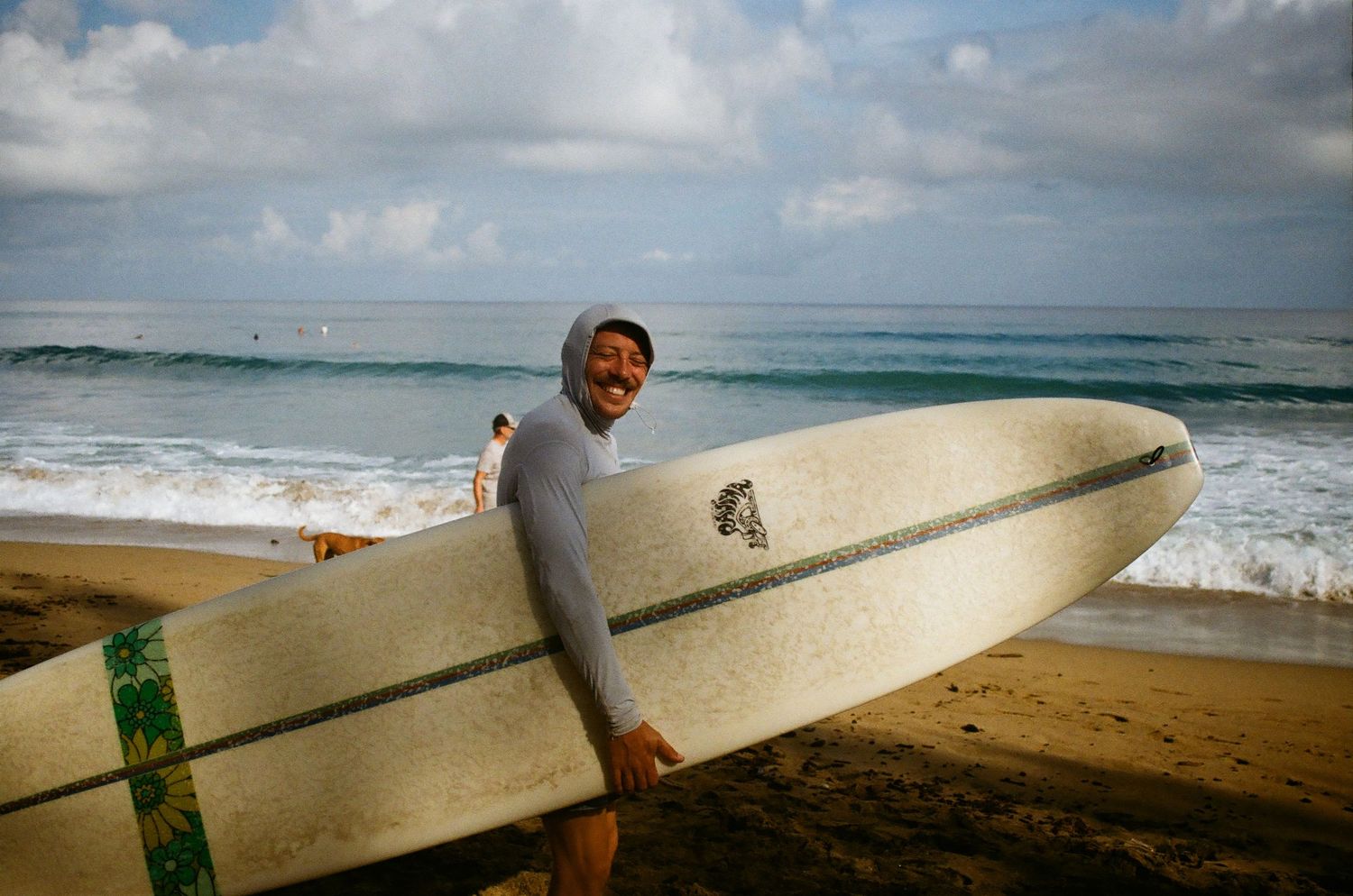 Lifestyle shot of surfer heading into the water to surf in Puerto Rico, shot on 35mm film
