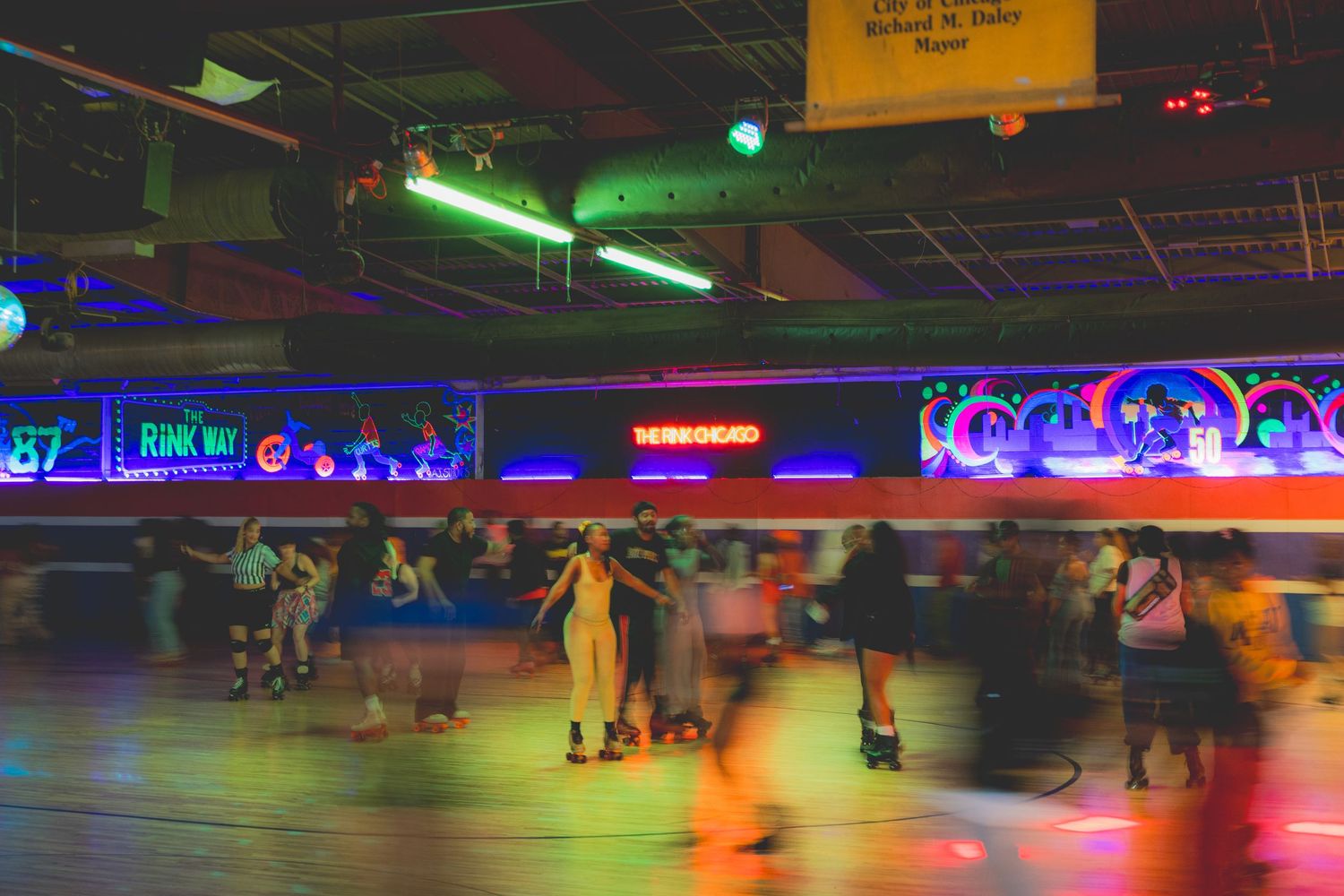 Colorful roller skating rink with skaters enjoying neon-lit evening session.