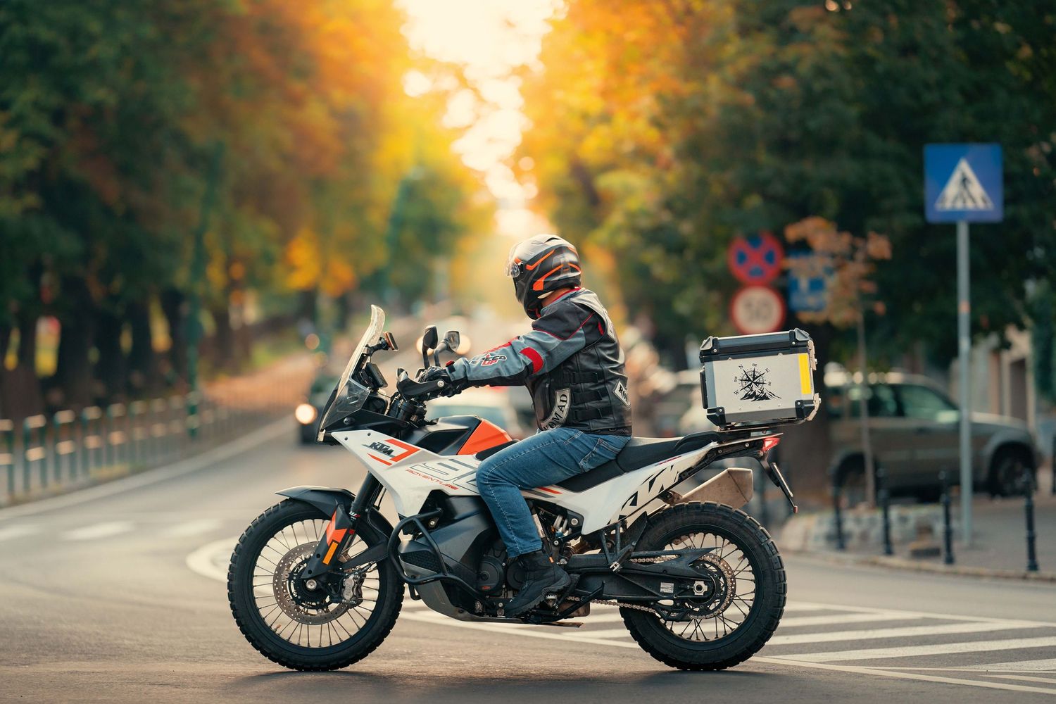 Custom motorcycle parked on autumn street during golden hour with fallen leaves.