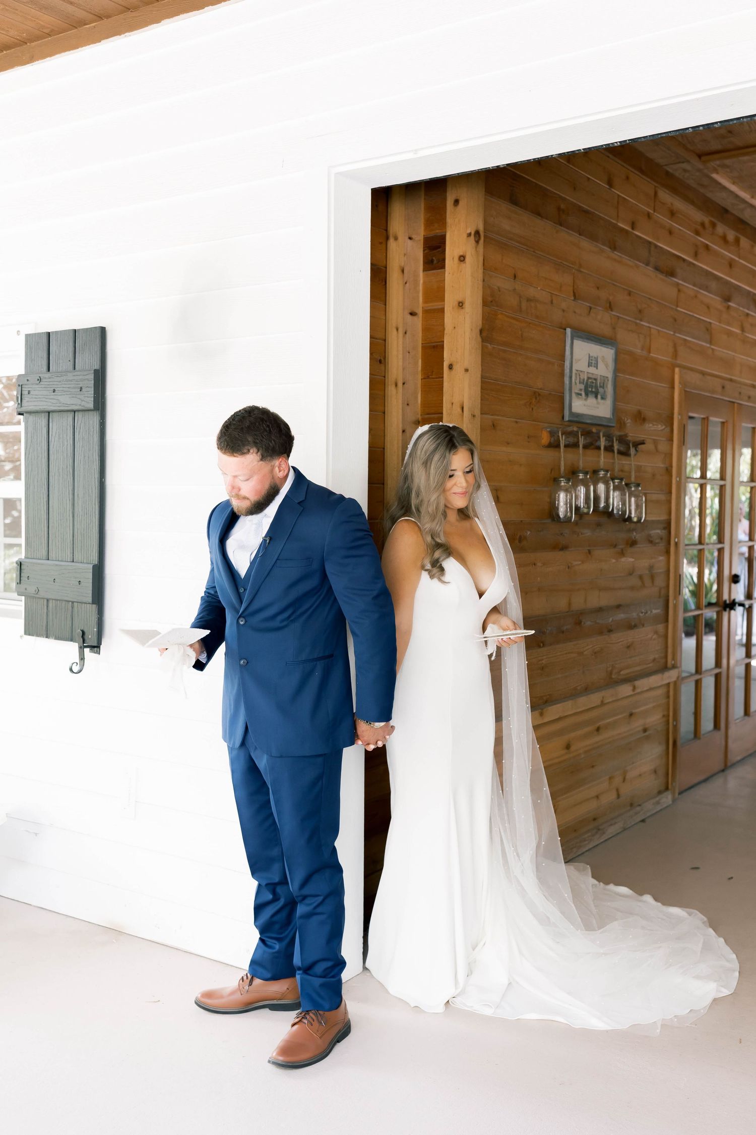 Rustic barn wedding first look sequence with couple separated by wooden wall.