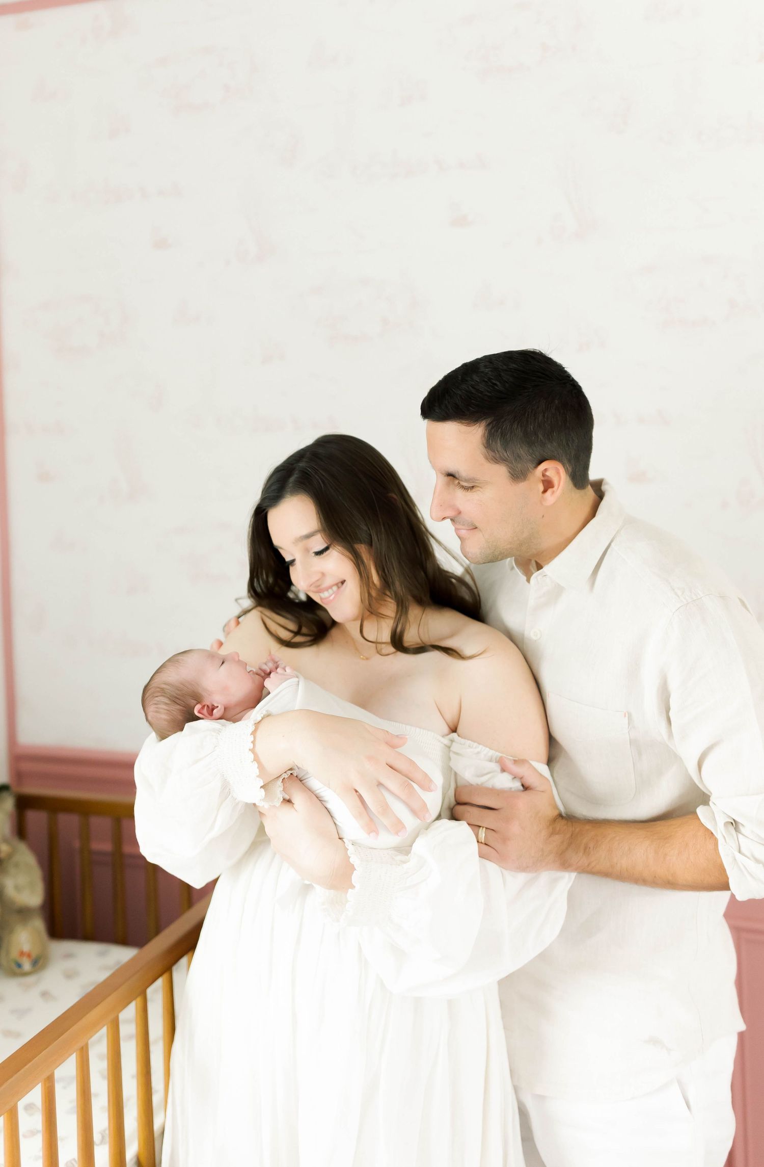 Loving family moment captured in bright nursery setting.