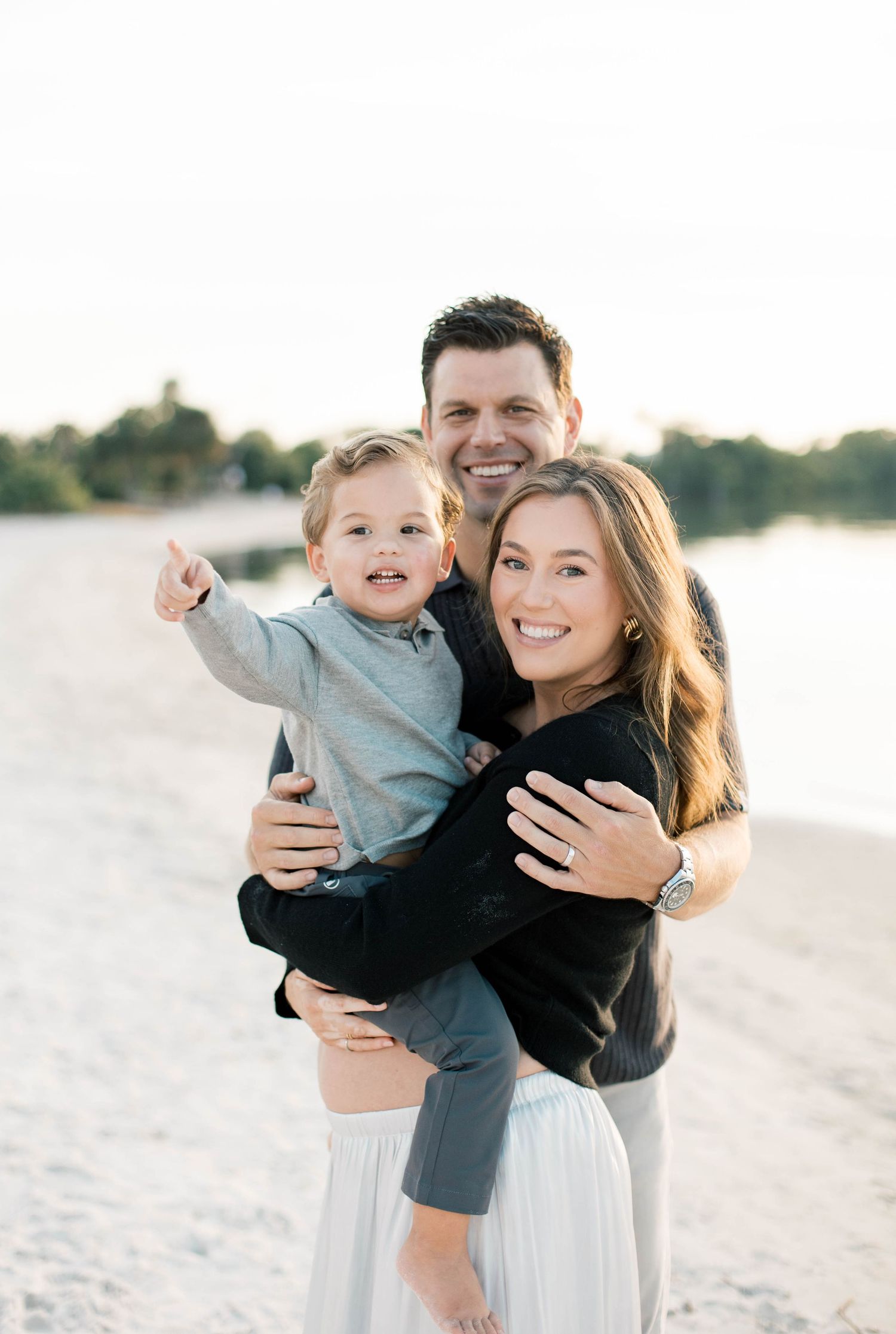 Family sharing joyful moments together on a white sandy beach.