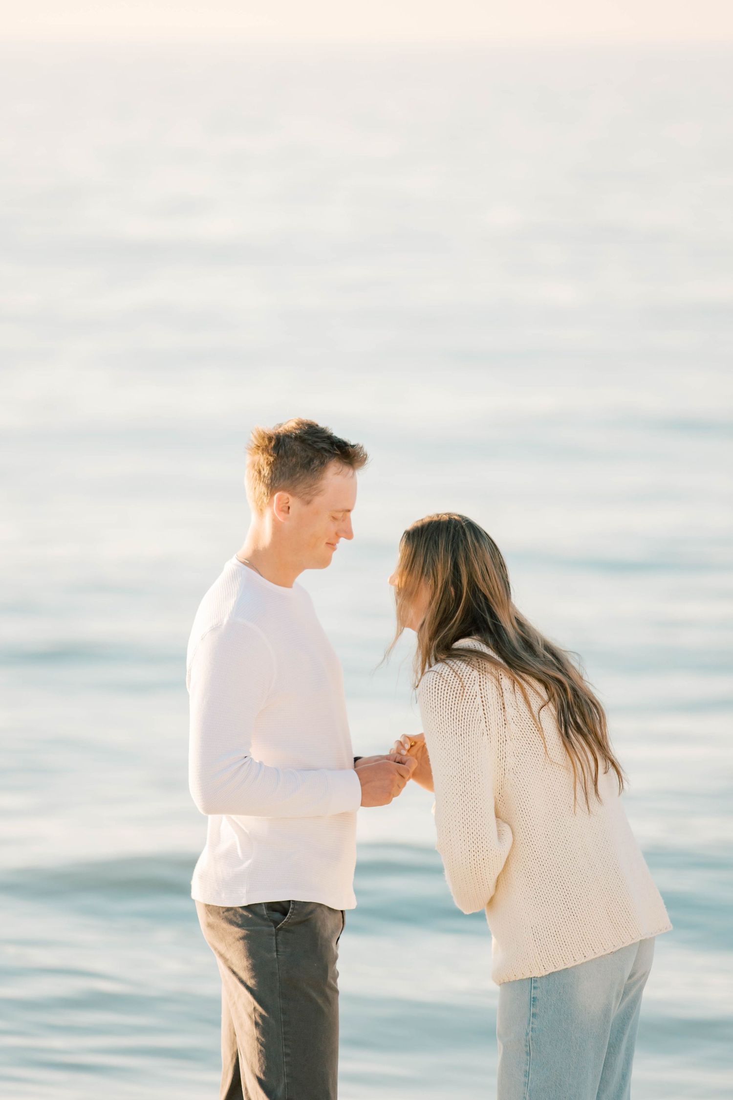 A tender moment between a couple on the beach during a sunset photoshoot.