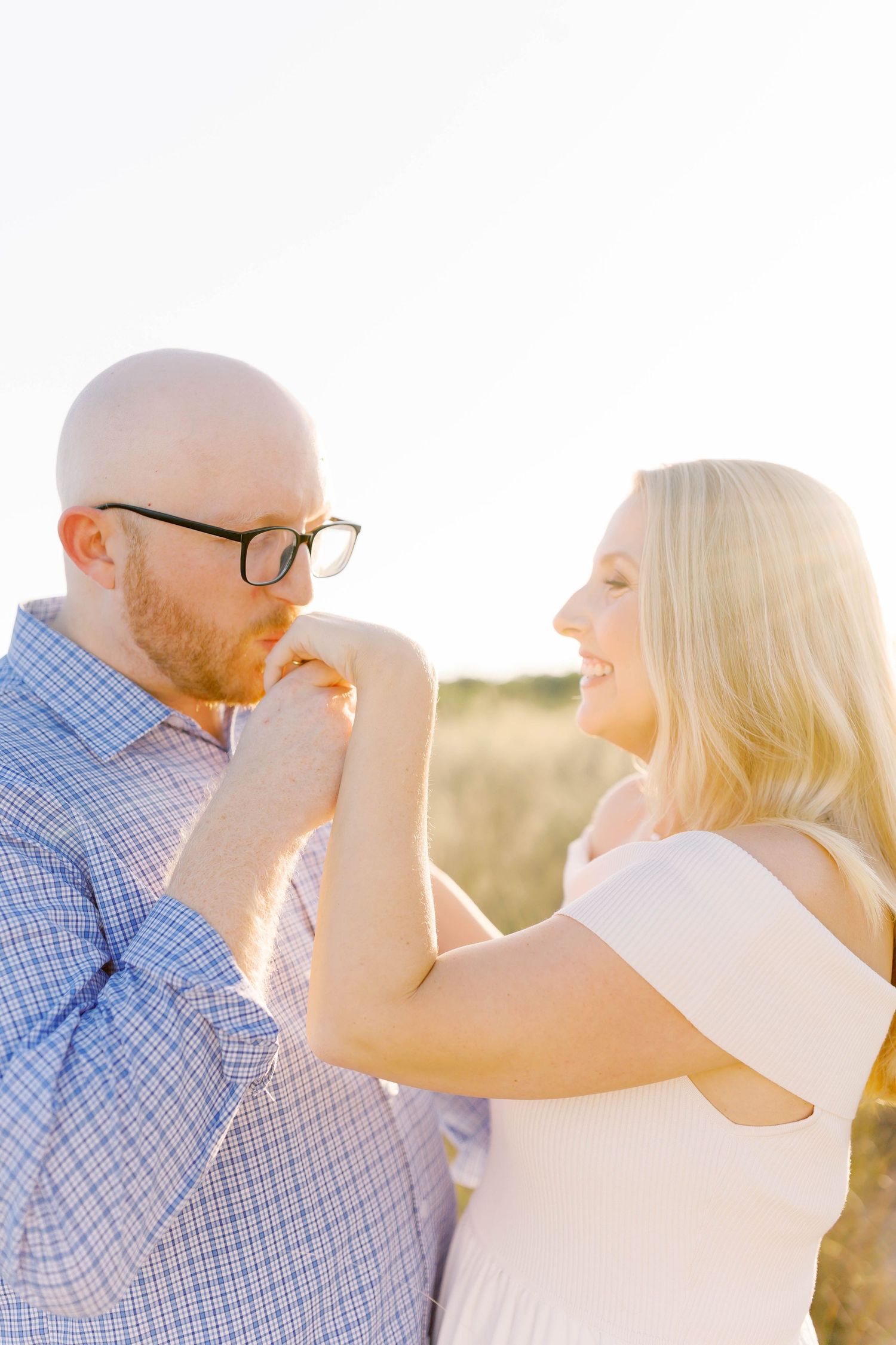 Intimate portraits of couple in sunlit field showing tender moments.