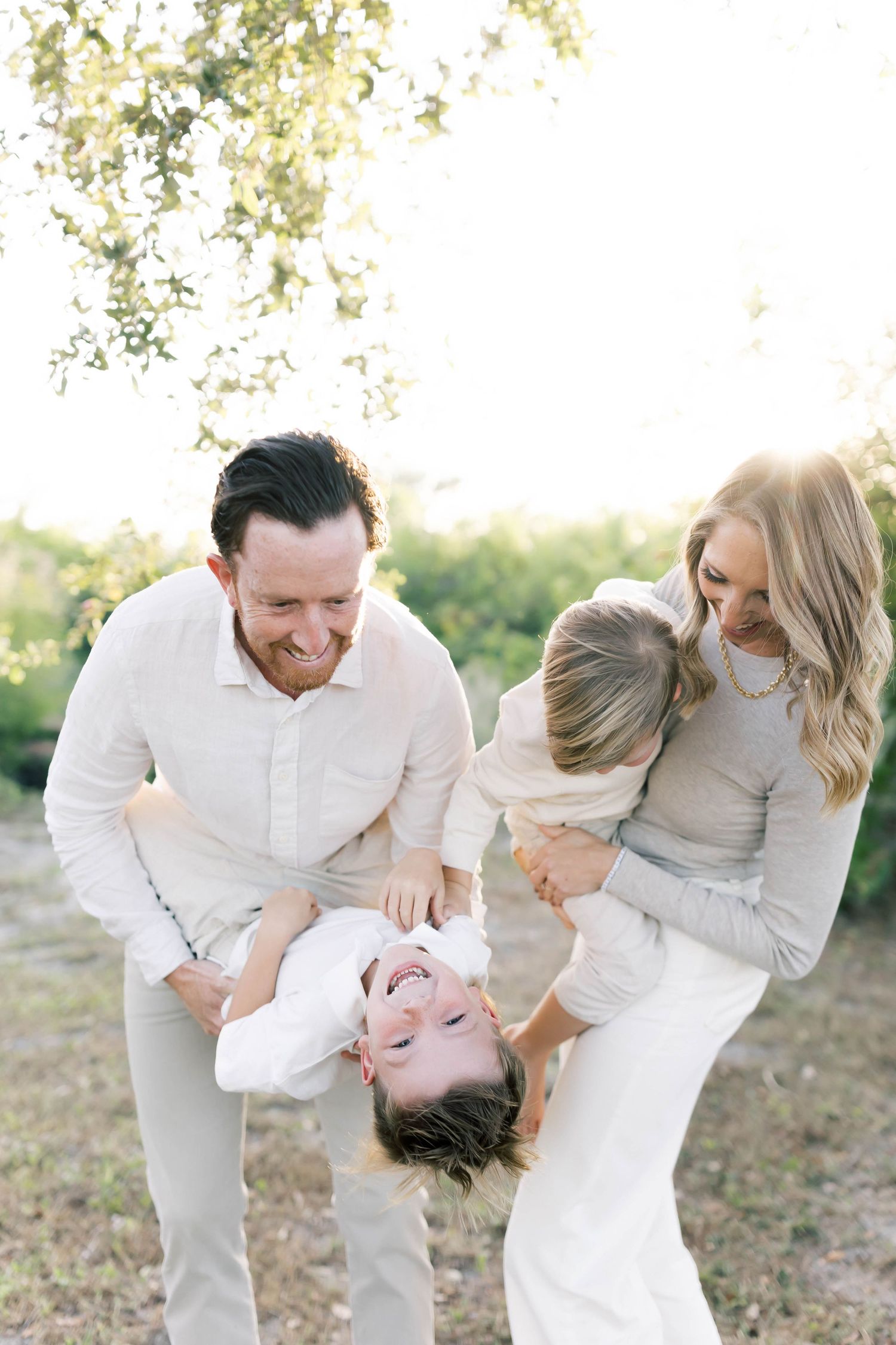 A playful family moment captured during sunset in a natural setting.