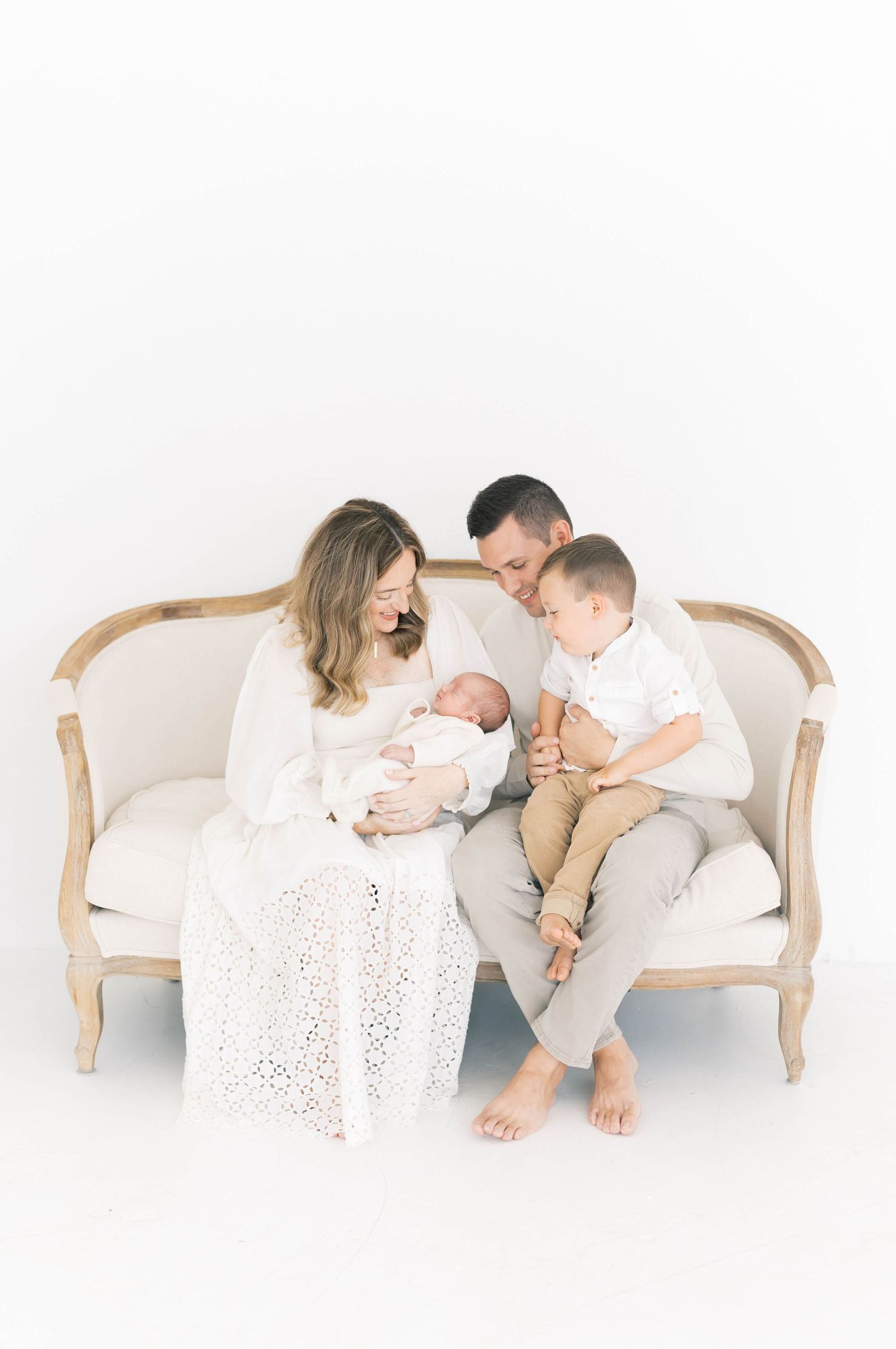 Lifestyle family photo session with parents and children on antique settee.