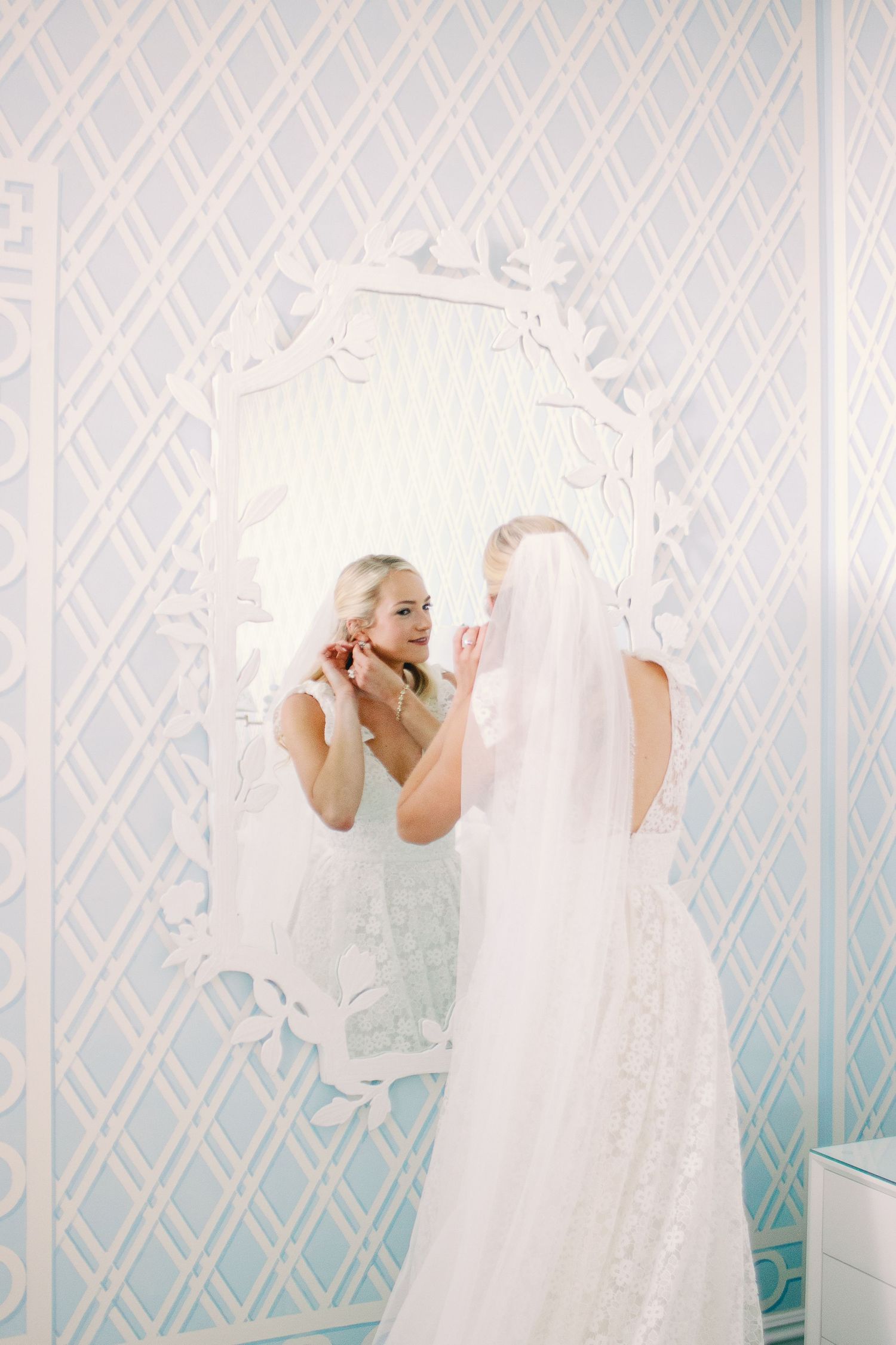 A sequence of photos showing someone in a white dress looking at themselves in a mirror with a blue patterned wallpaper.