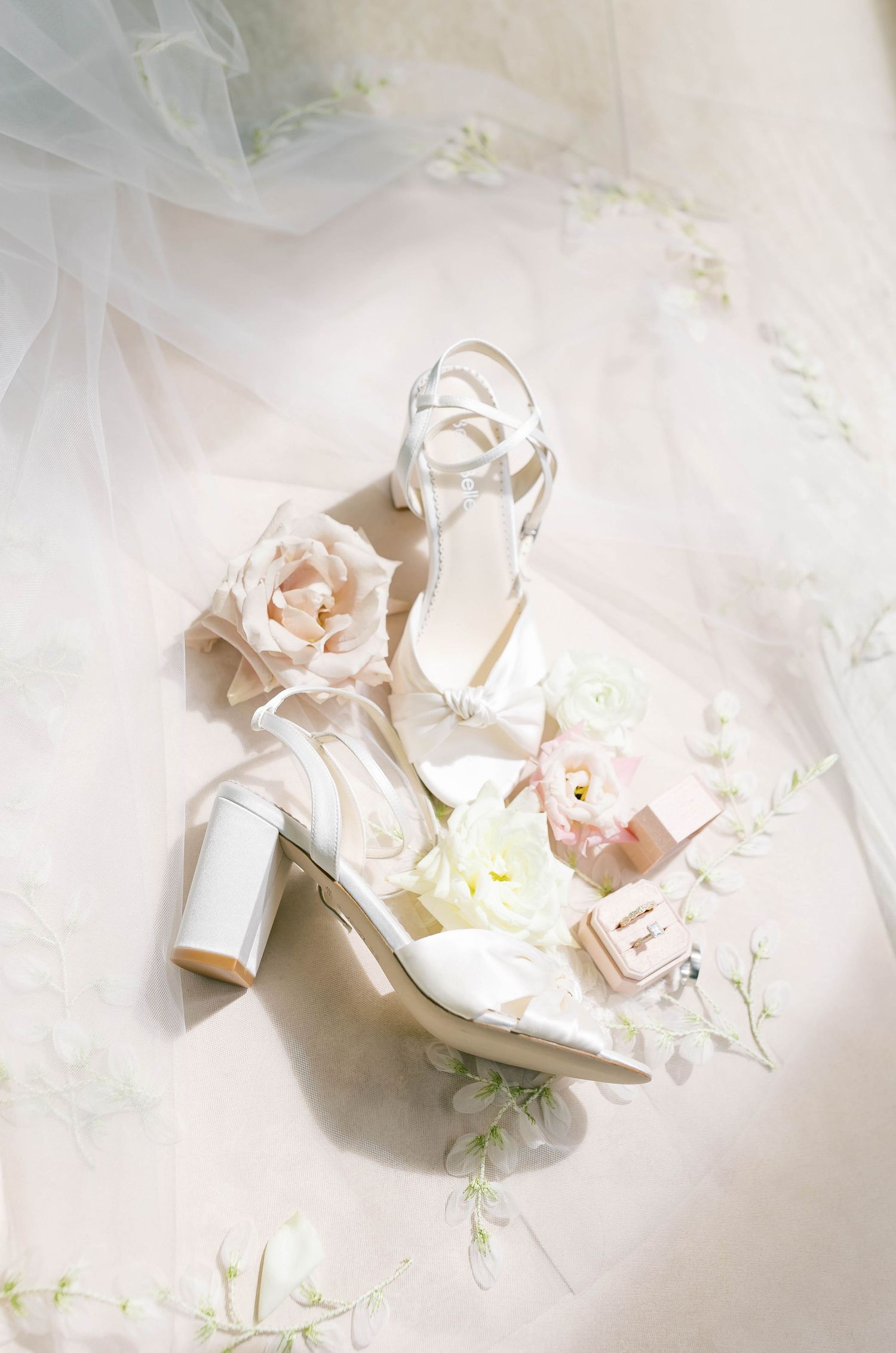 Ballet pointe shoes in soft pink satin lay gracefully arranged on a light textured background.