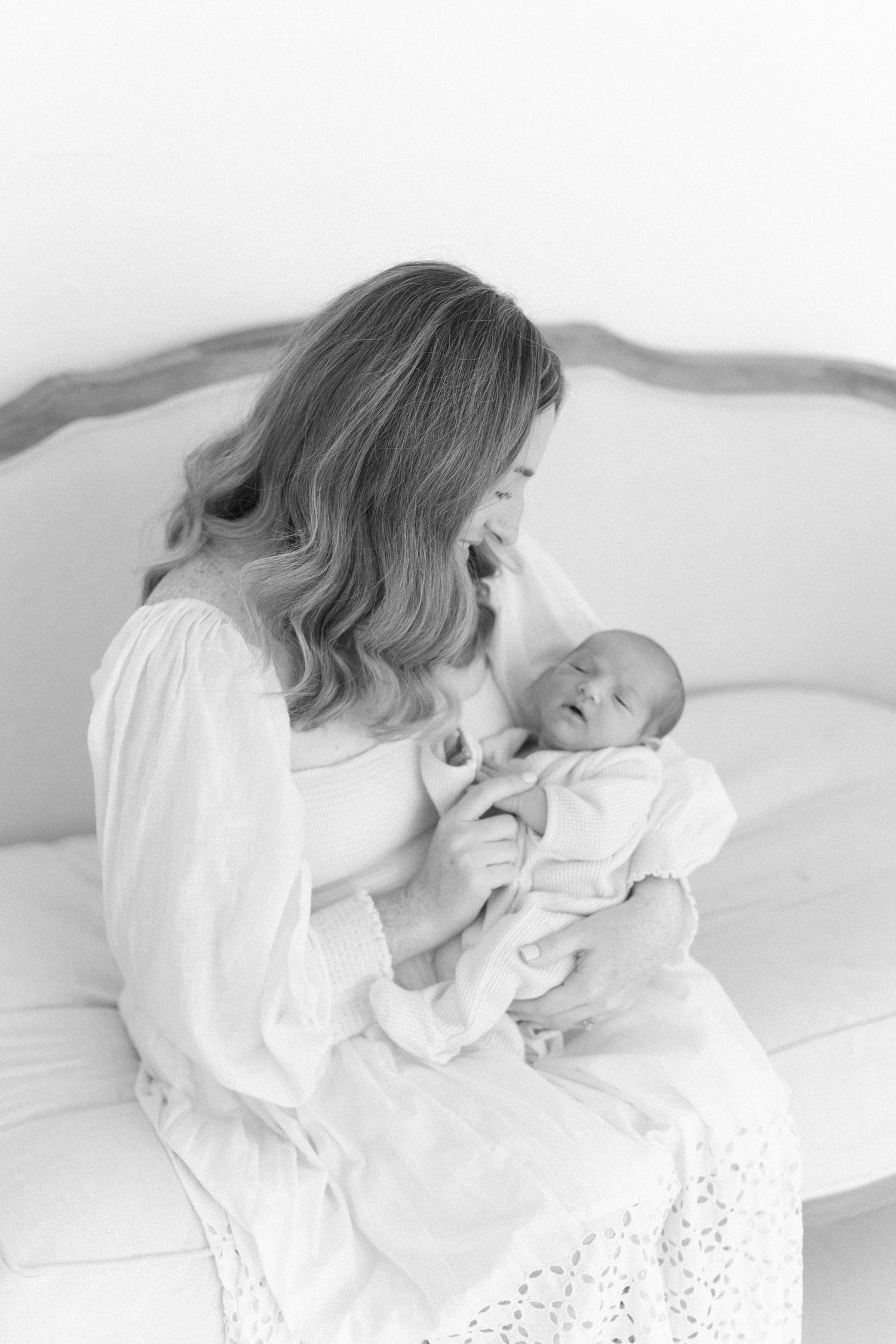 Intimate black and white portraits of mother and baby in soft natural light.