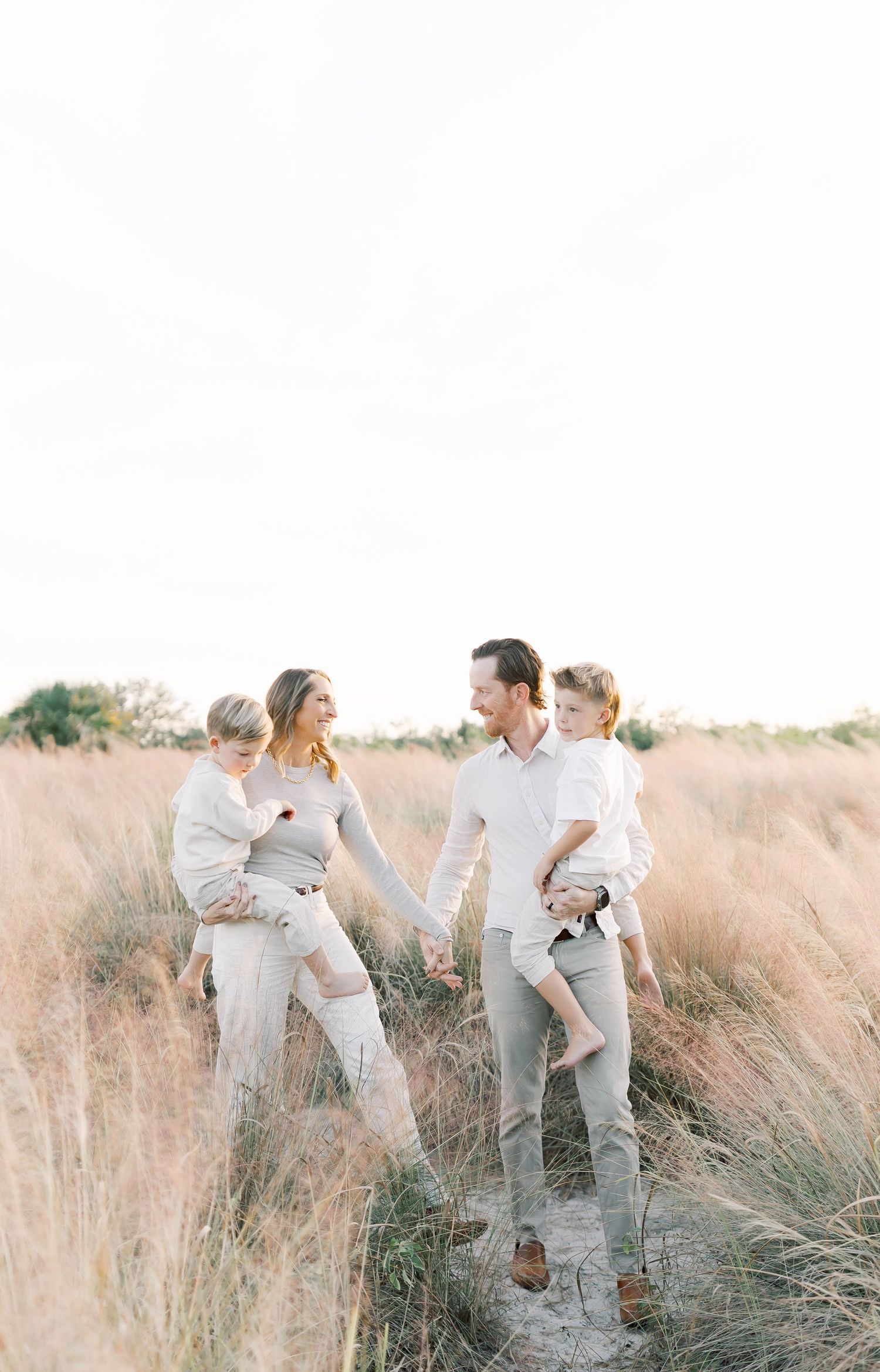 Playful family moments captured in a field during golden hour.