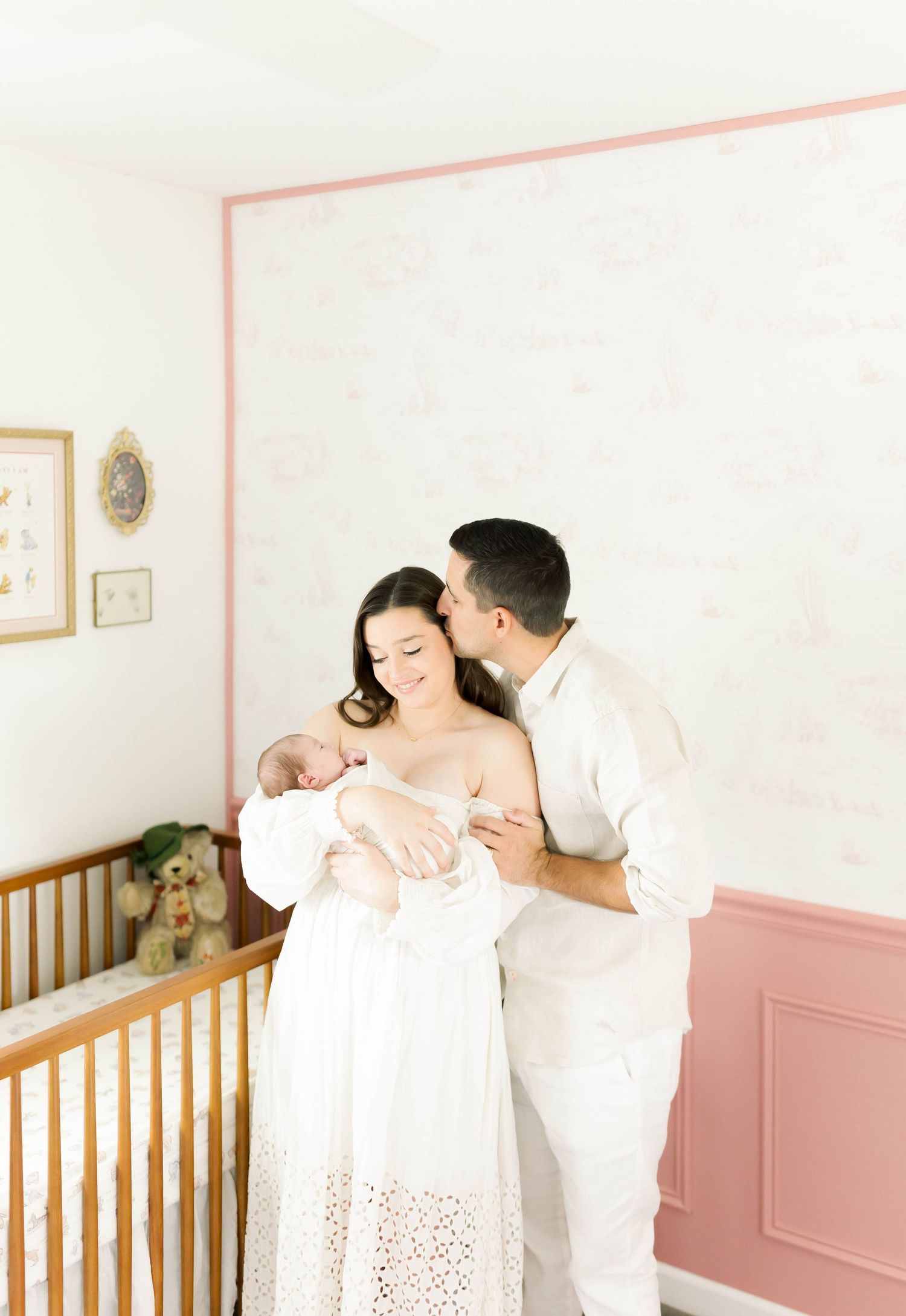 Intimate family photography session in minimalist nursery setting.