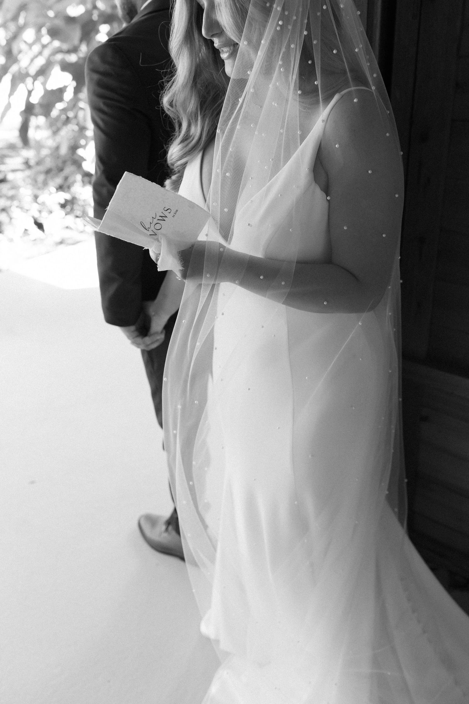 Black and white photo of intimate first look moment at rustic wedding venue.