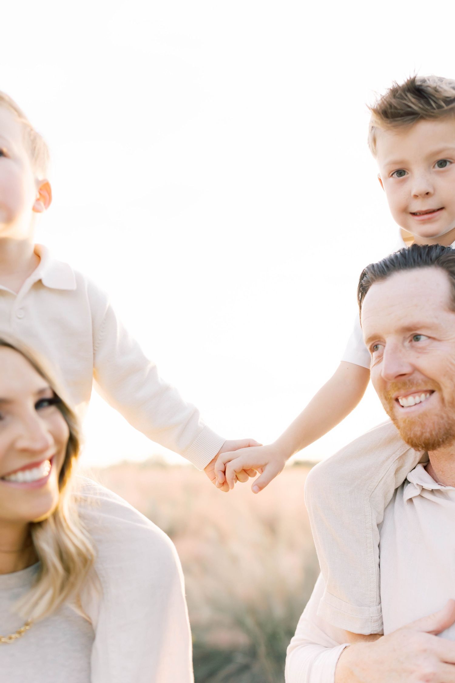 Intimate family portrait session with golden sunlight and white outfits.