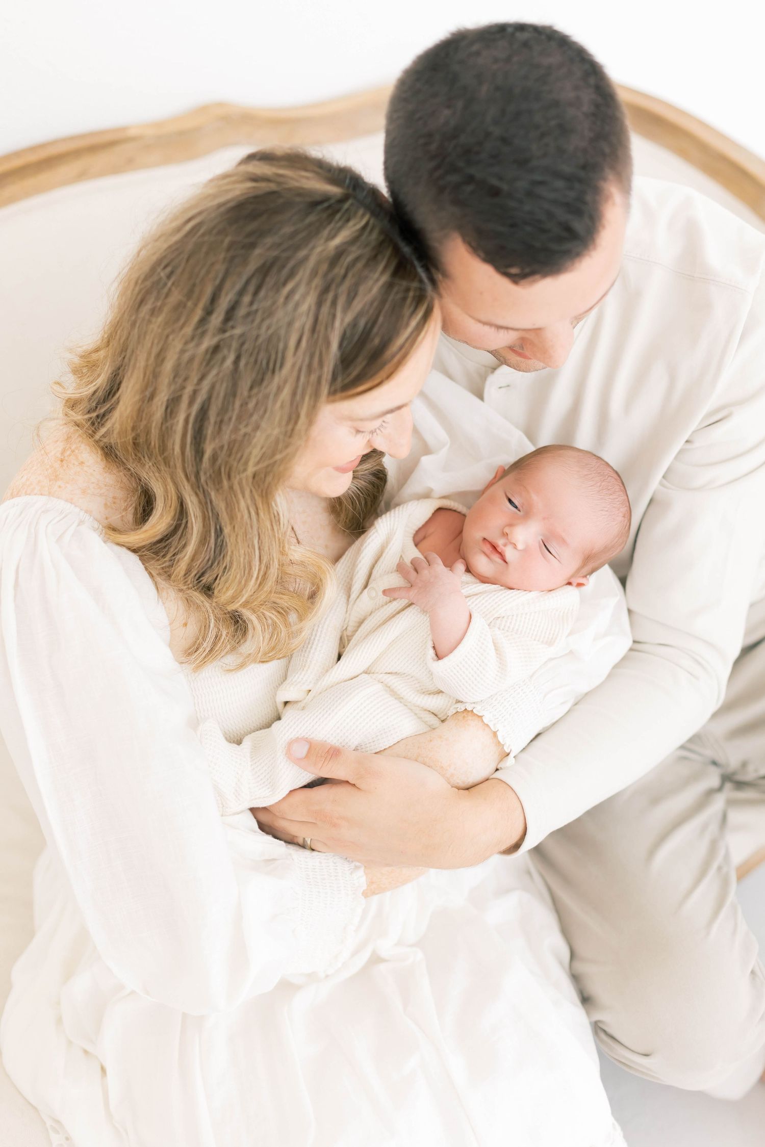 Intimate family portraits in white with soft natural lighting and neutral tones.