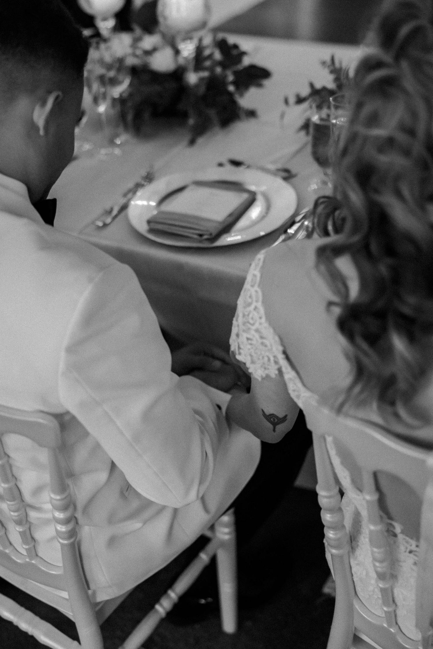 White chairs and elegant table settings arranged for a formal wedding reception.