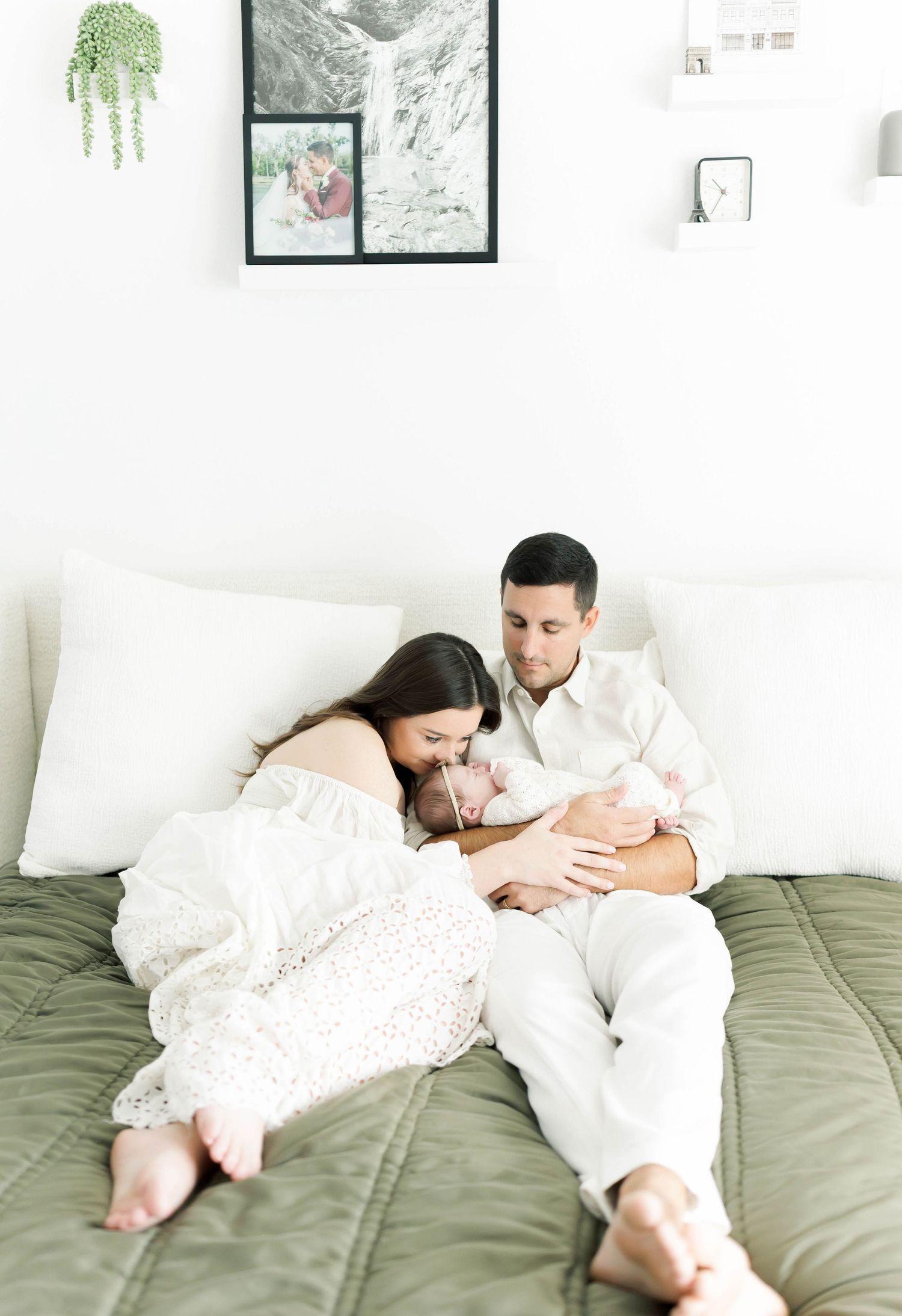 Lifestyle family photos on bed with olive green bedding and white walls.