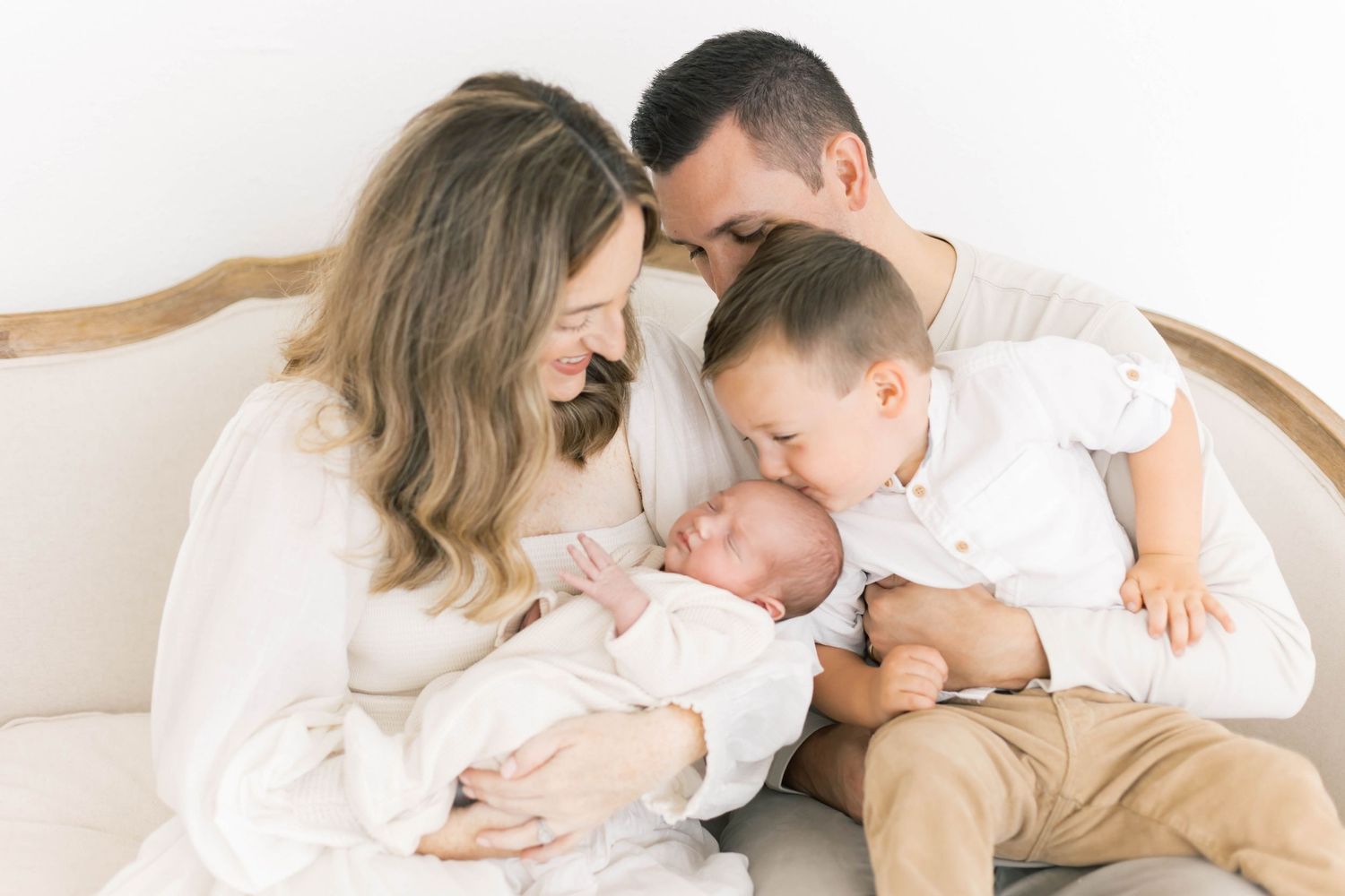 Candid family moments captured in white studio setting with natural lighting.