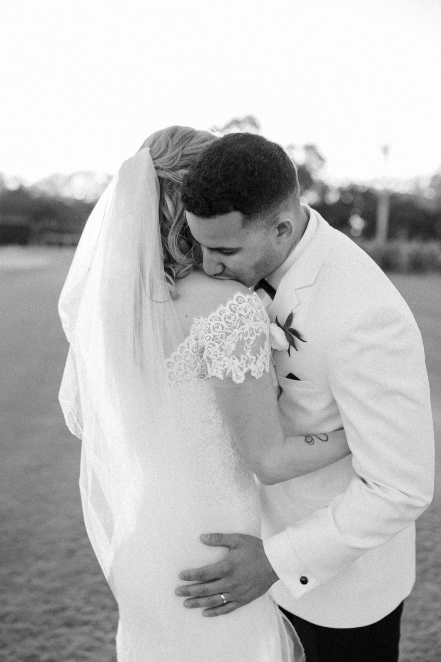 Intimate black and white wedding photos showing tender moments between newlyweds.