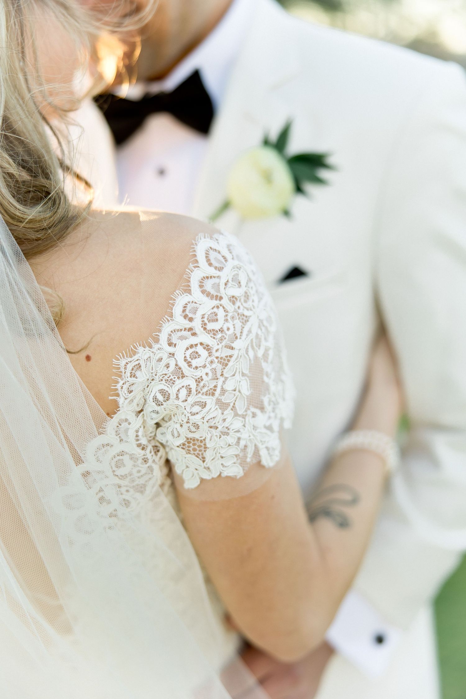 Delicate lace detail of wedding dress bodice captured in natural light.