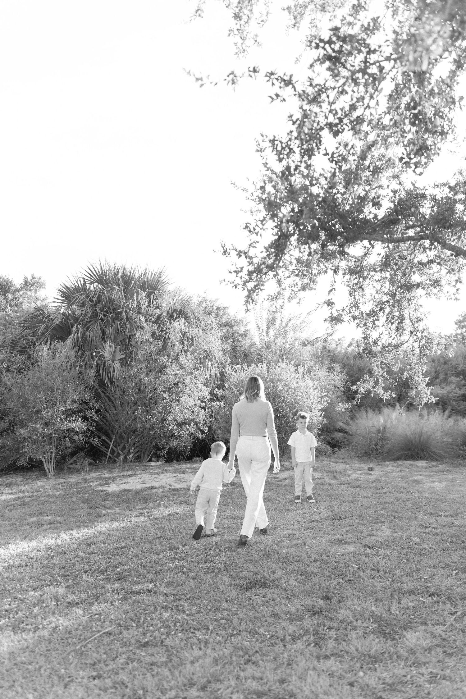 Black and white photo of a family walking together in a scenic outdoor setting.