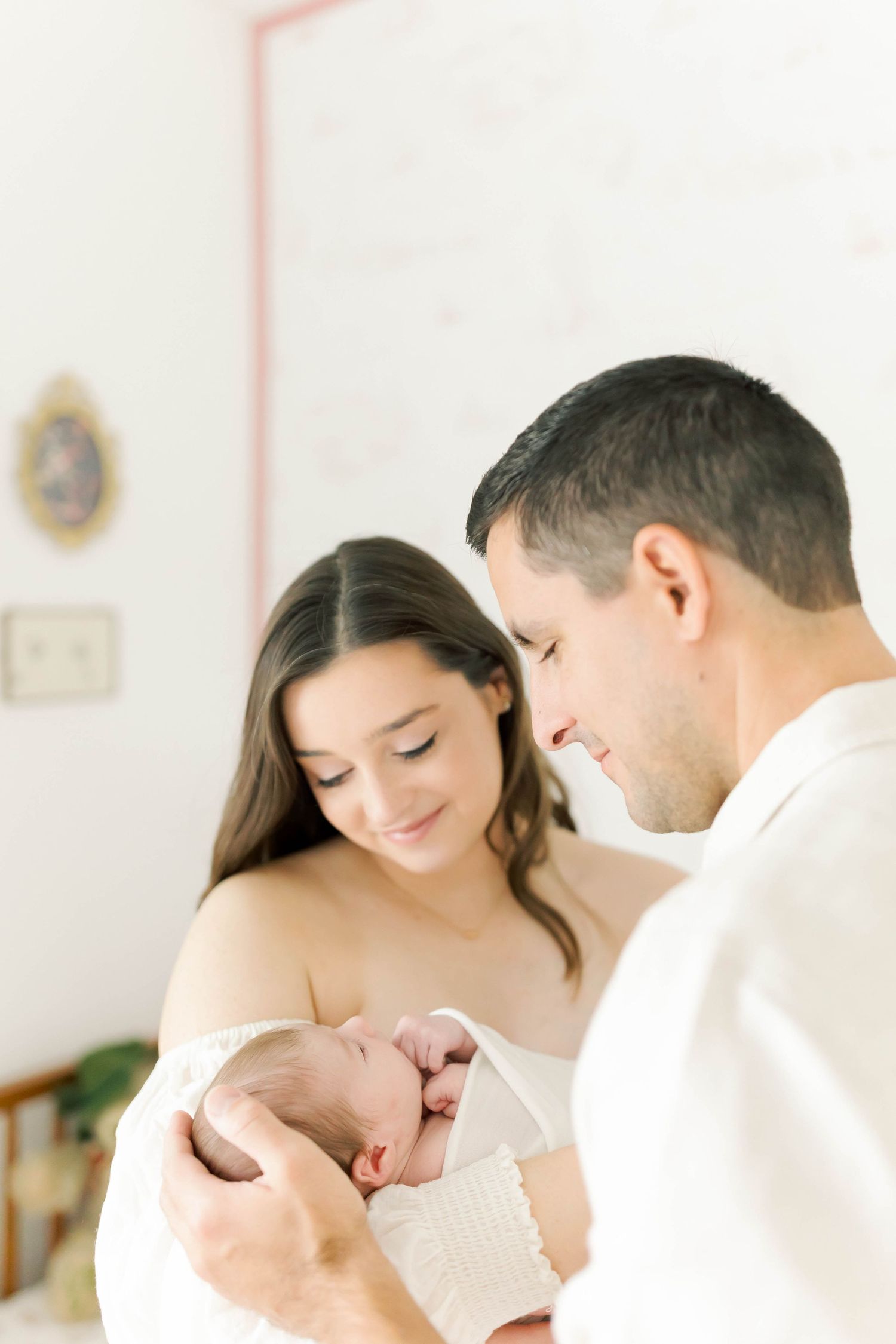 Intimate close-up portrait in soft natural light against white background.