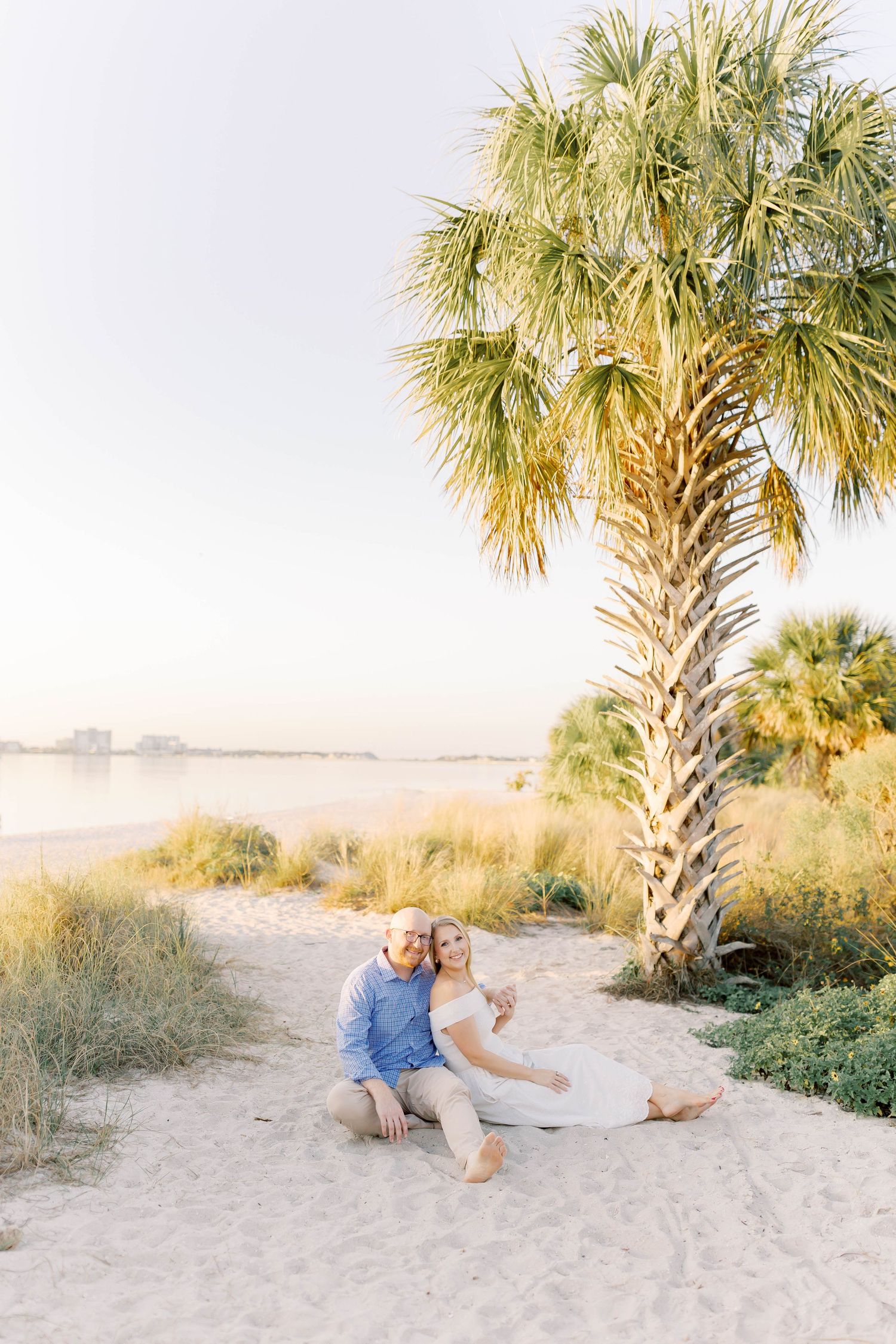 Couple enjoying romantic moment on sandy beach with palm trees.