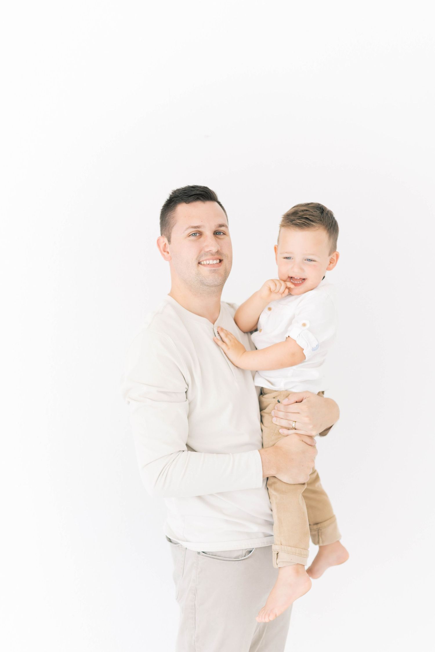 Joyful parent-child moments captured against white background in studio.