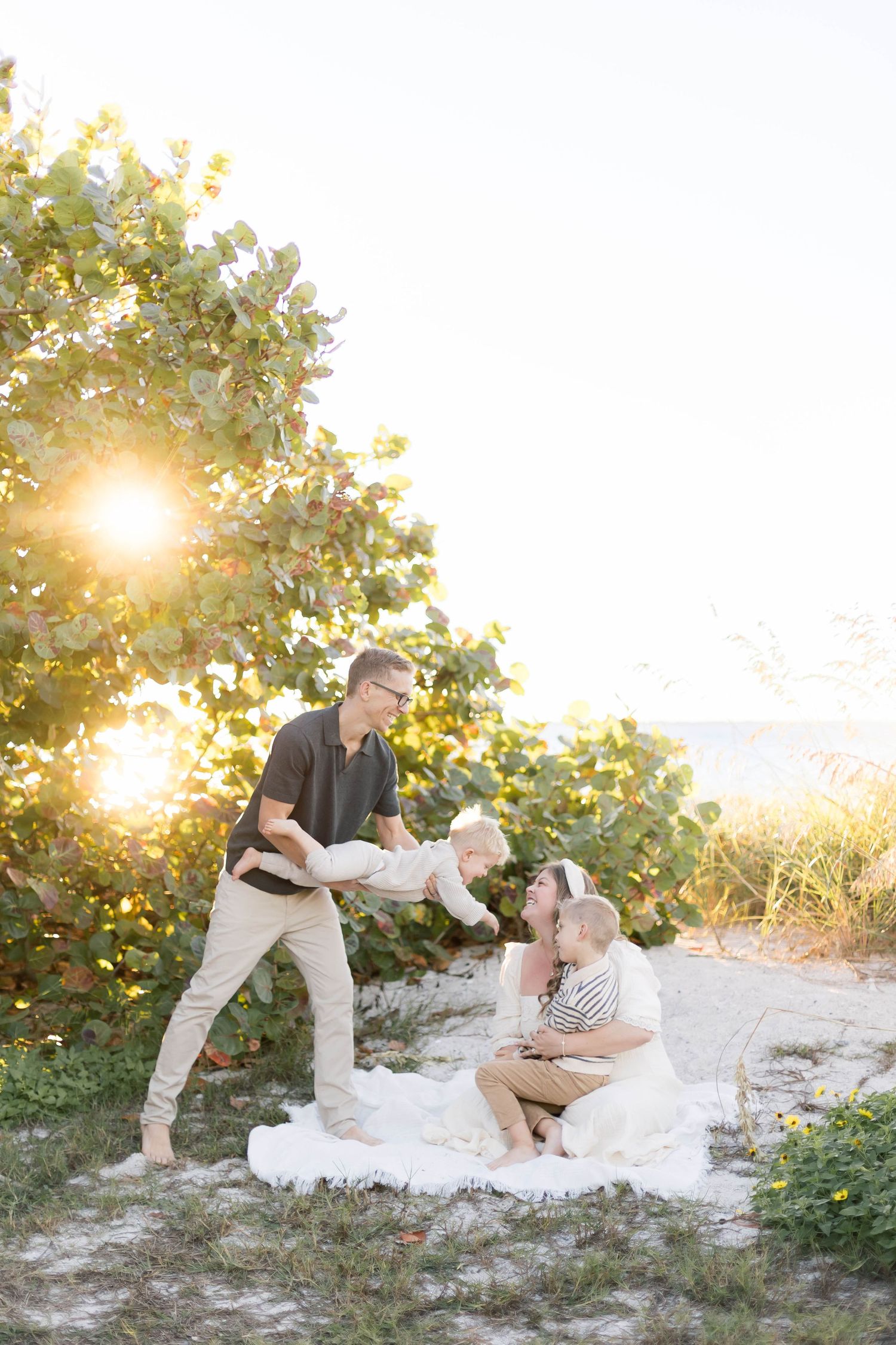 Playful family moment captured during sunset photoshoot outdoors.