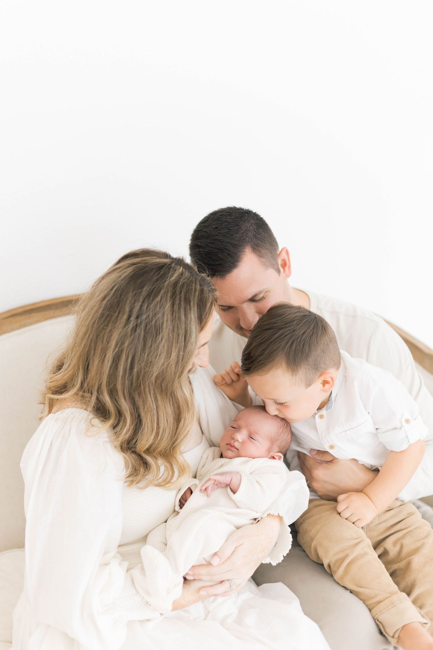Intimate family photos showing tender moments between parents and child on white background.