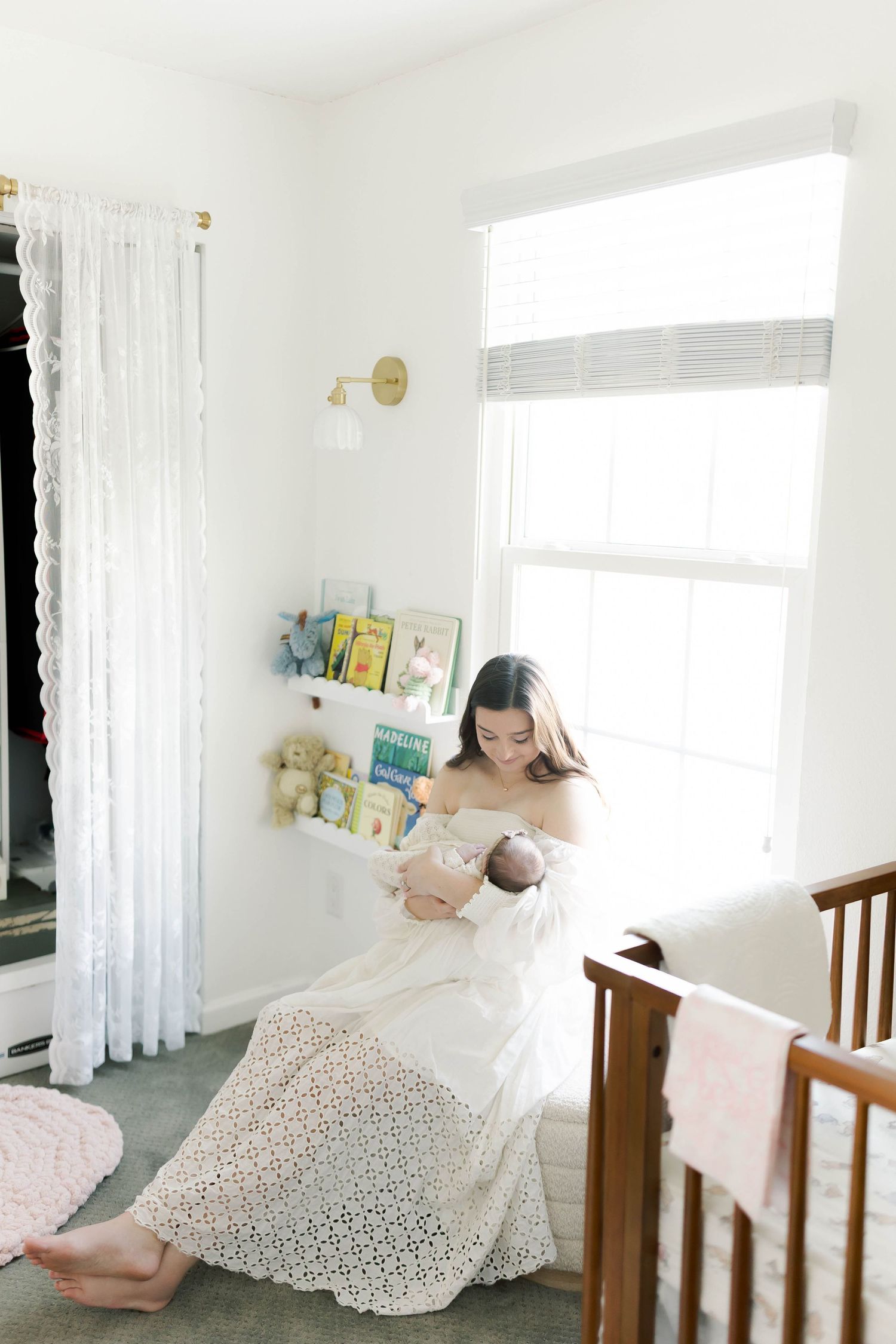 Bright nursery corner with parent holding baby near window and floating bookshelves.
