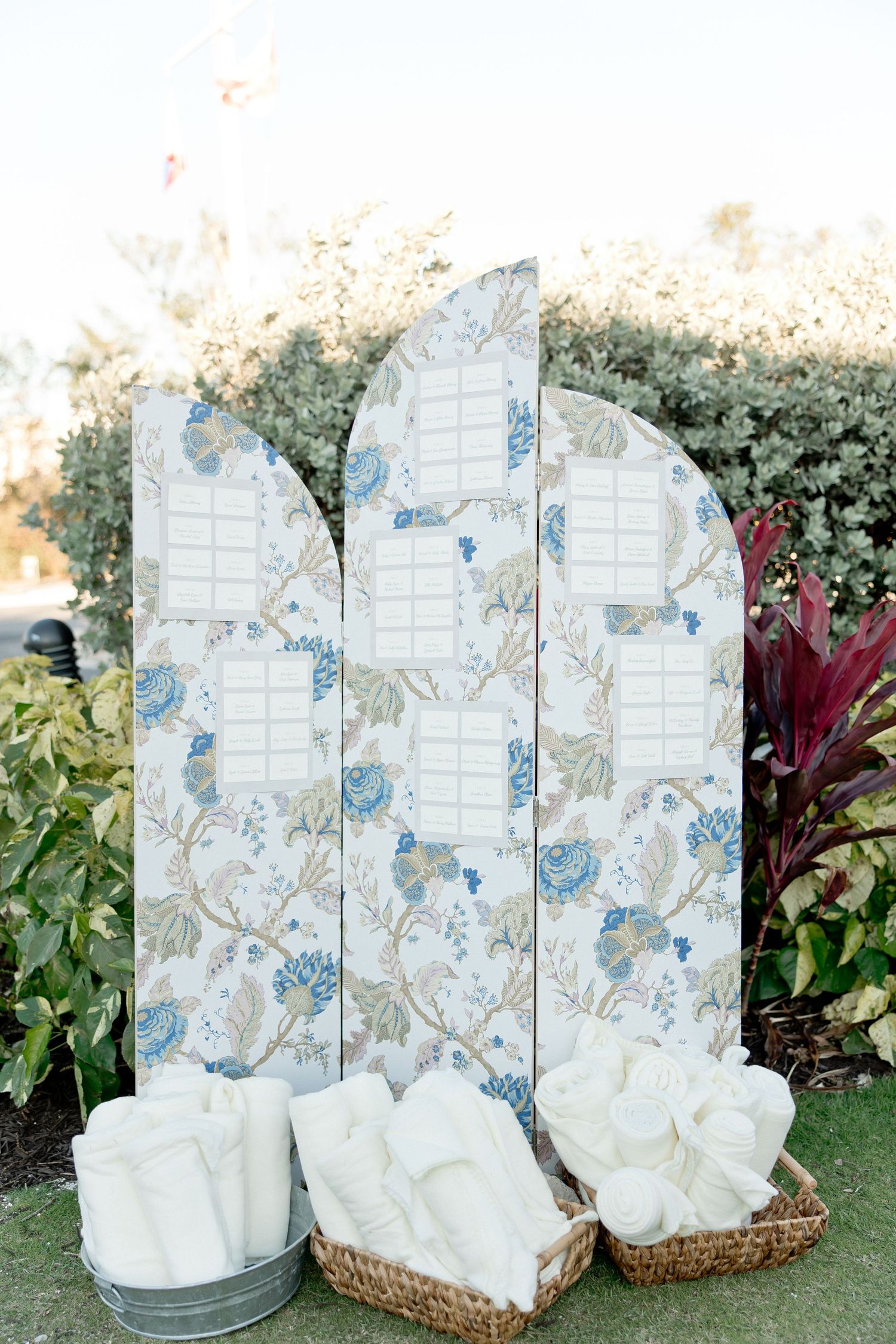 Decorative floral pattern screens with white blankets in baskets.