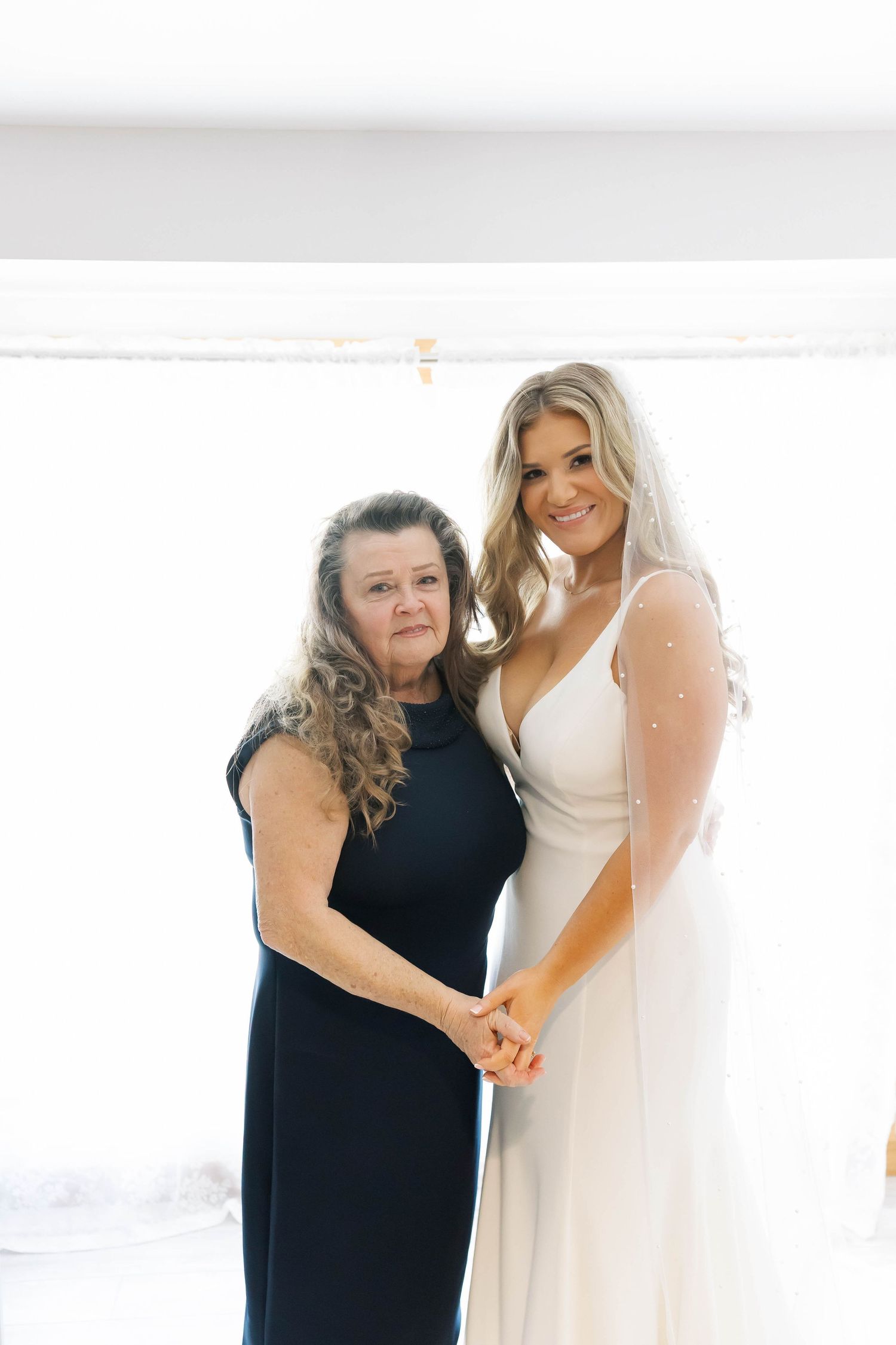 Emotional wedding day moment between two people in contrasting black and white dresses.