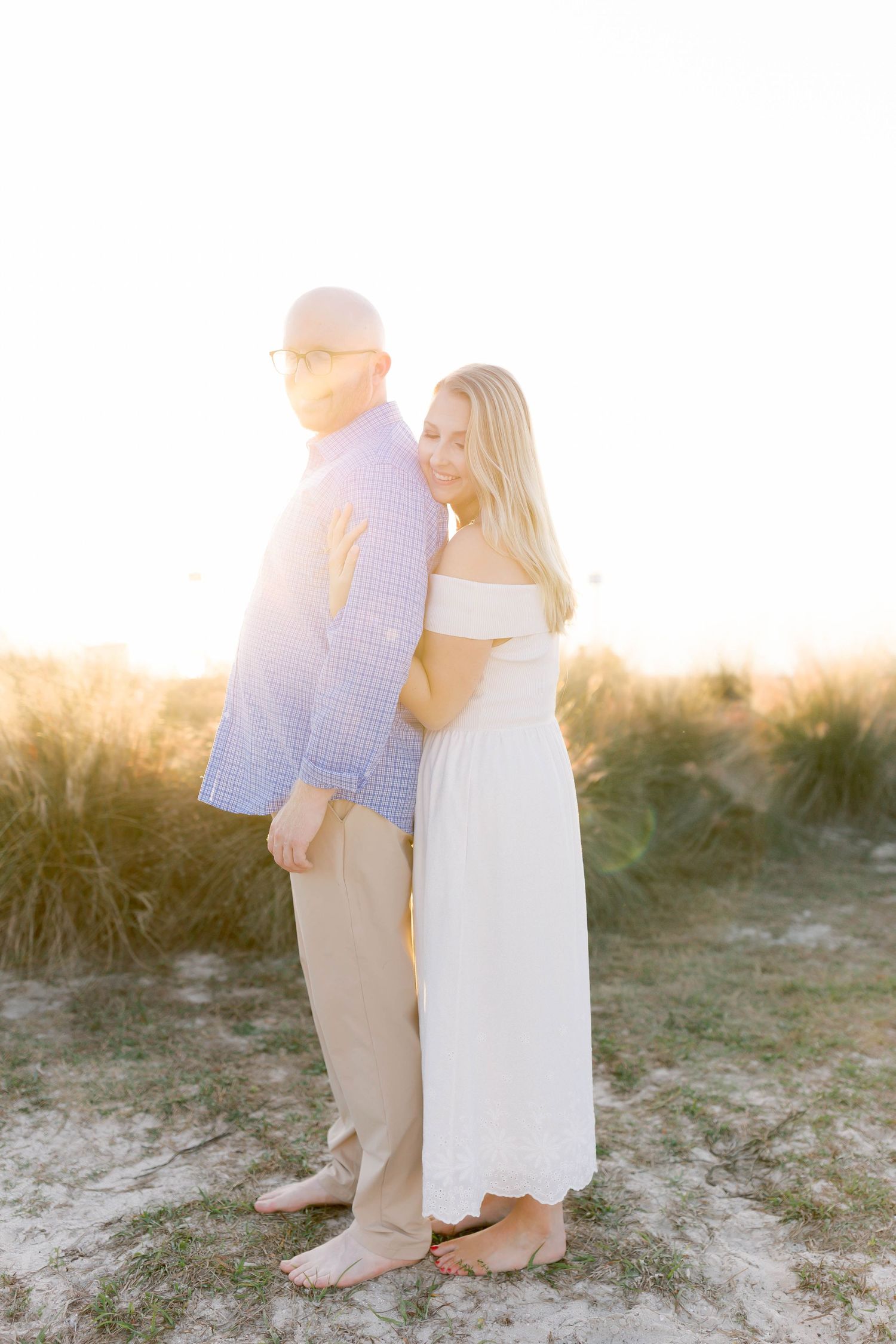 Intimate beach portrait session with couple in casual attire during sunset.