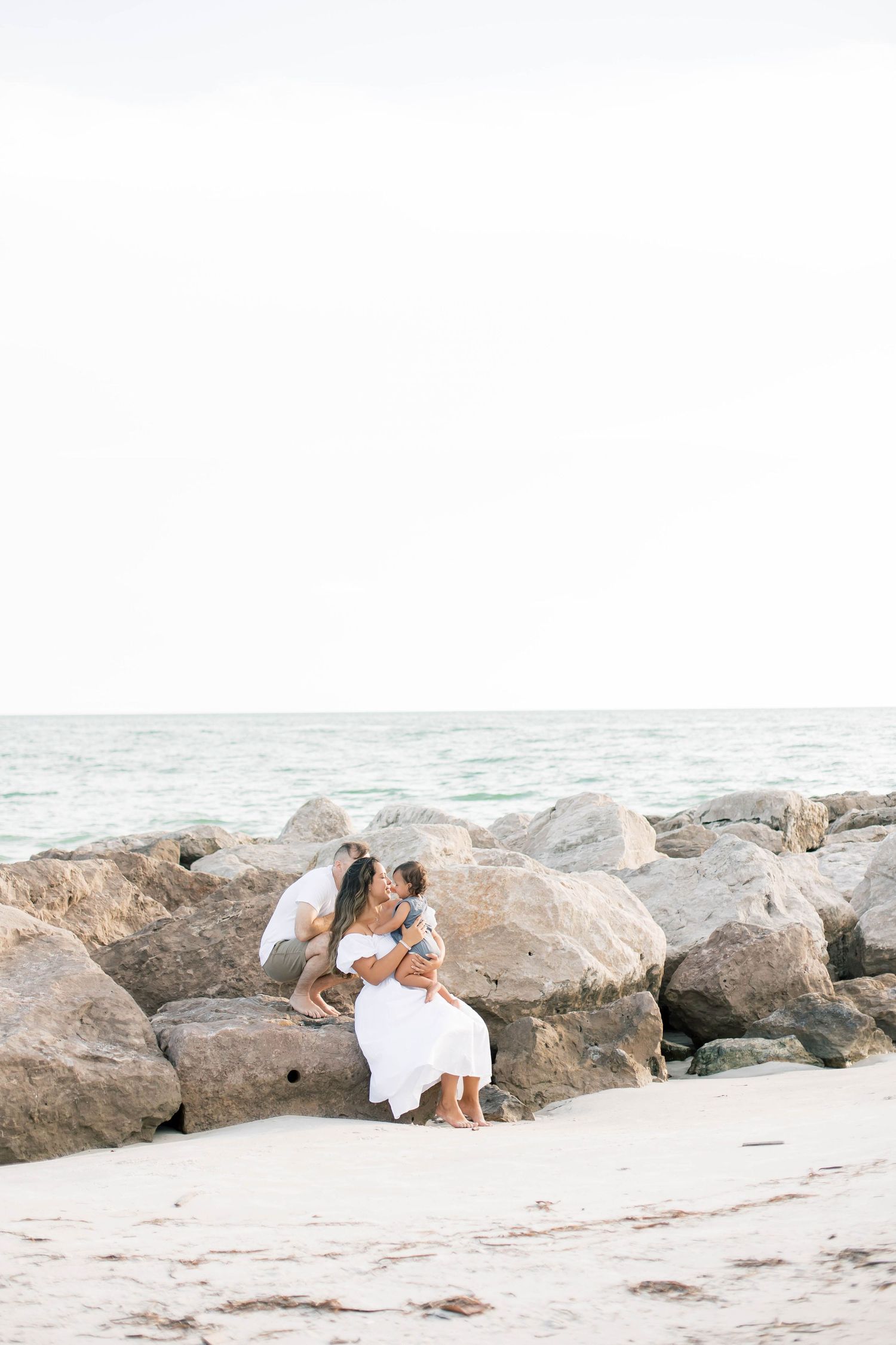 Beautiful beach photography session with family among coastal rocks.