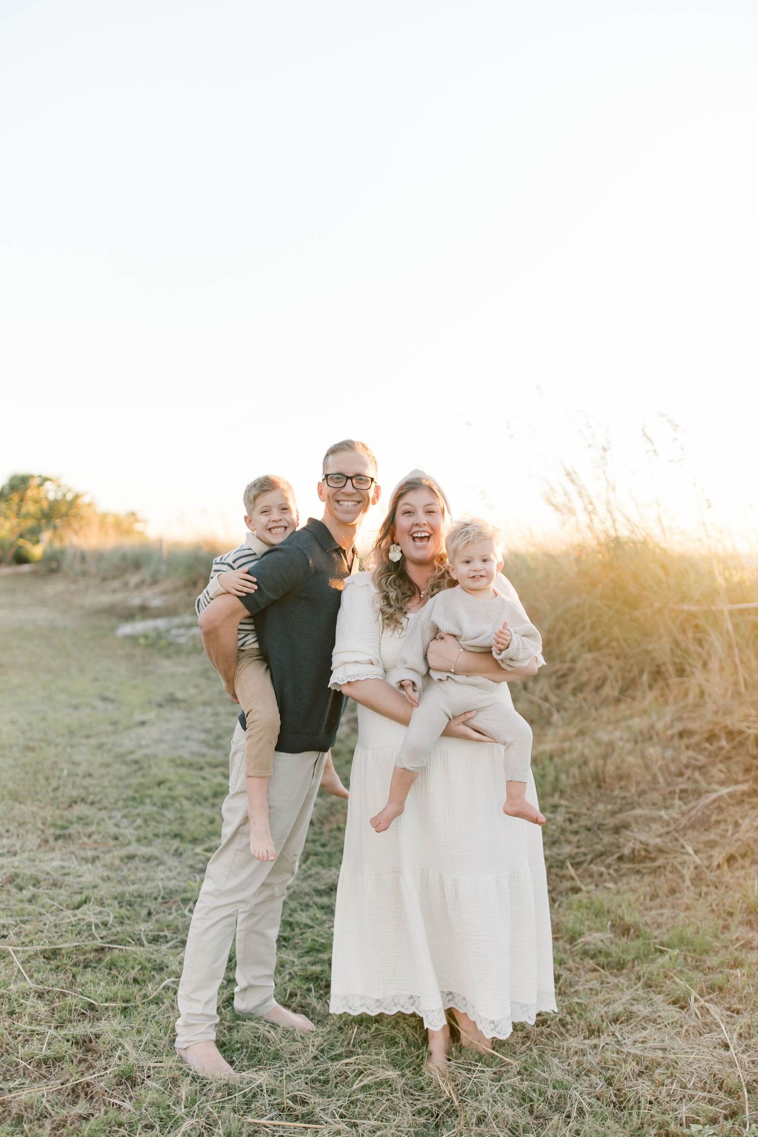 Happy family enjoying golden hour outdoors in casual attire.