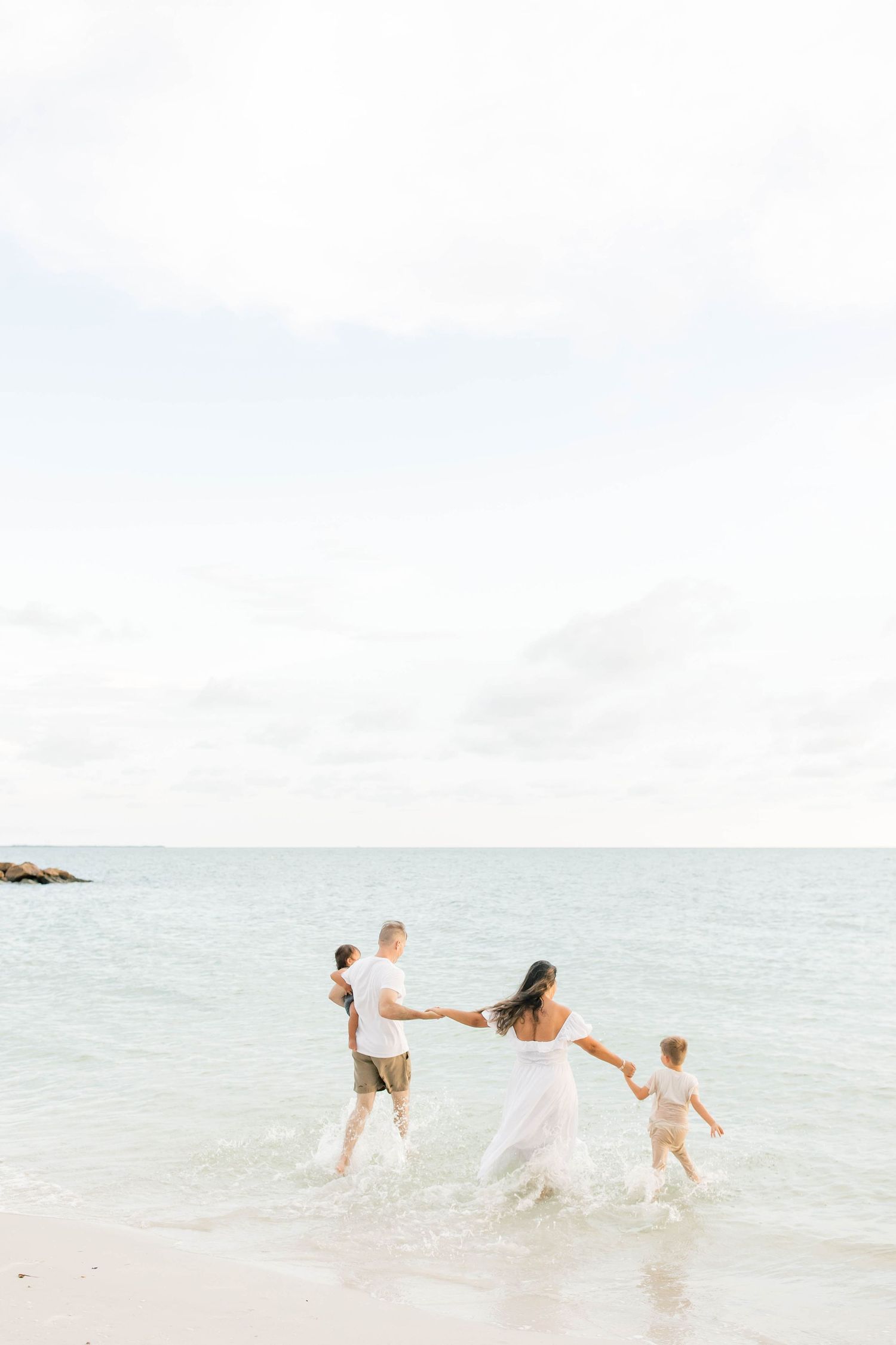 Playful family moment captured as they splash in the crystal clear ocean waters.
