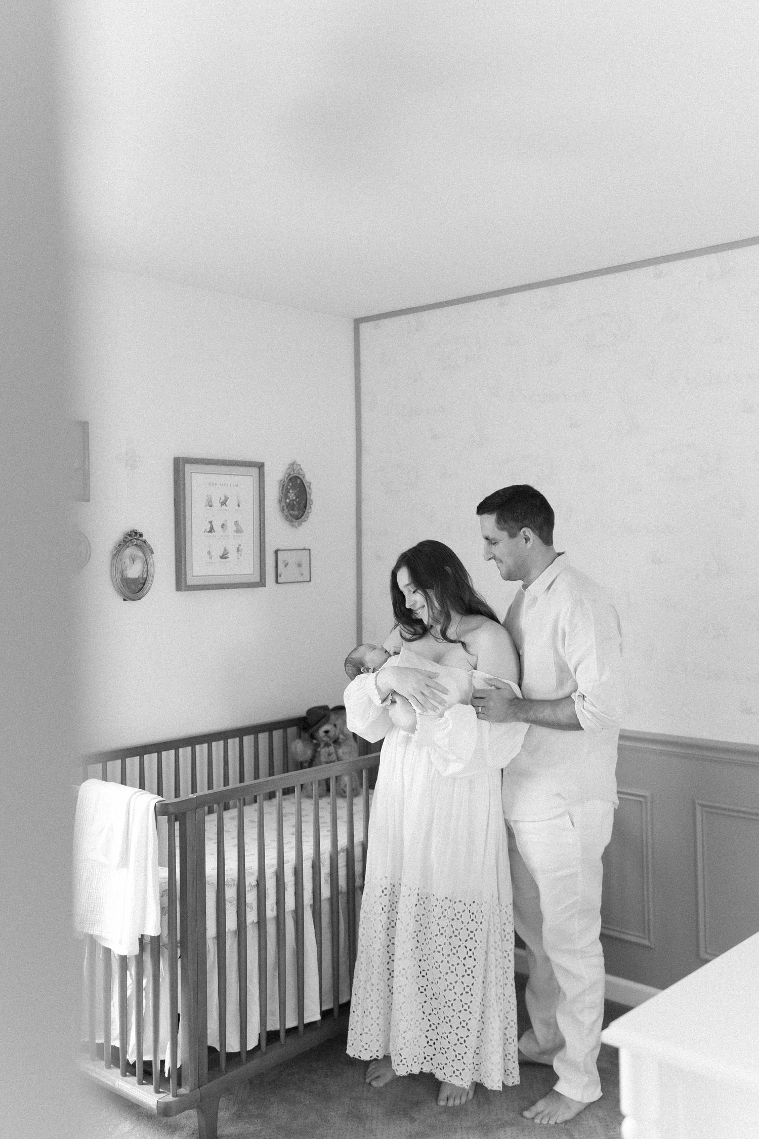 Elegant nursery photoshoot with wooden crib and soft lighting.